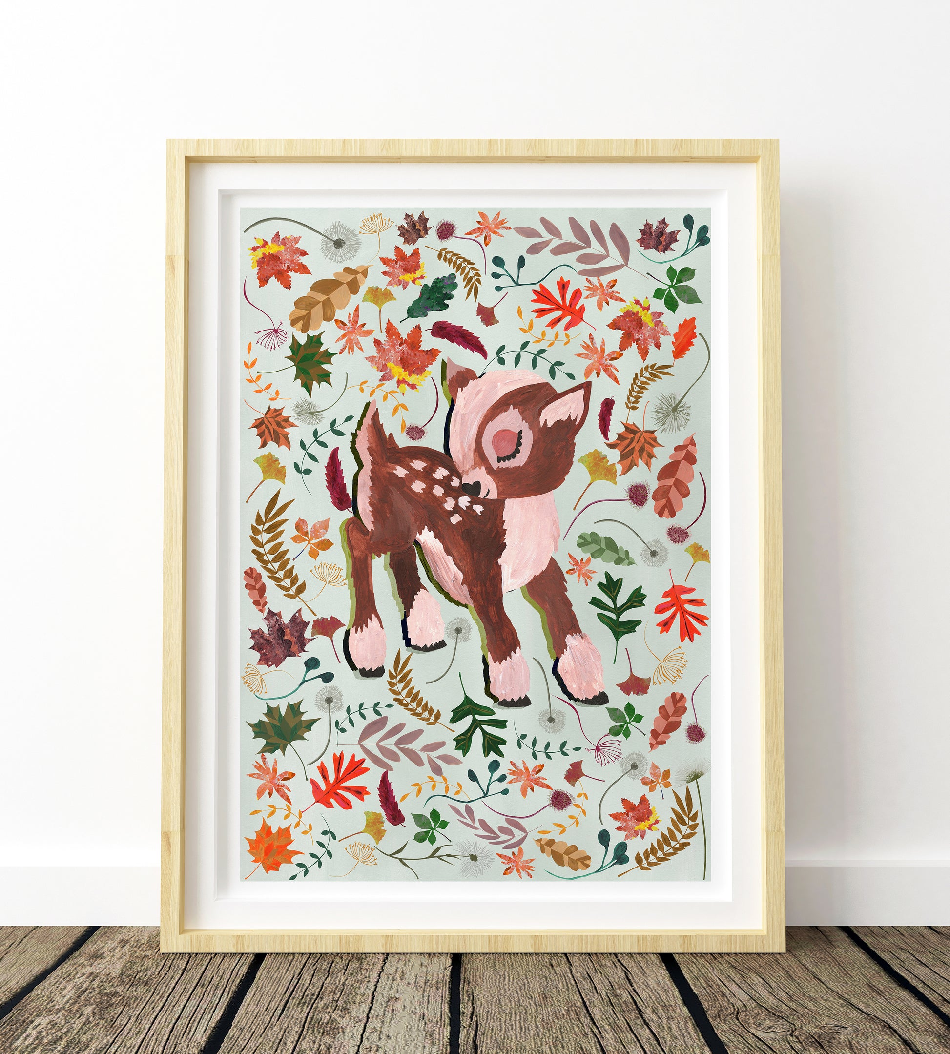 Framed artwork of a deer surrounded by autumn leaves on a white background