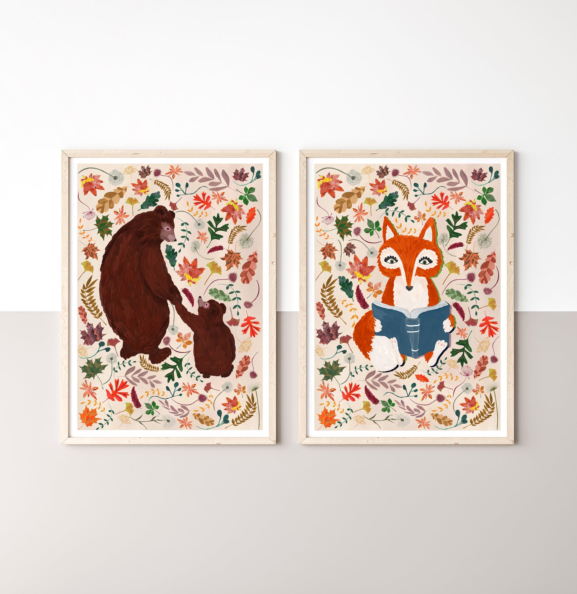 Two framed illustrations of a bear and cub, and a fox reading a book, on a white wall.