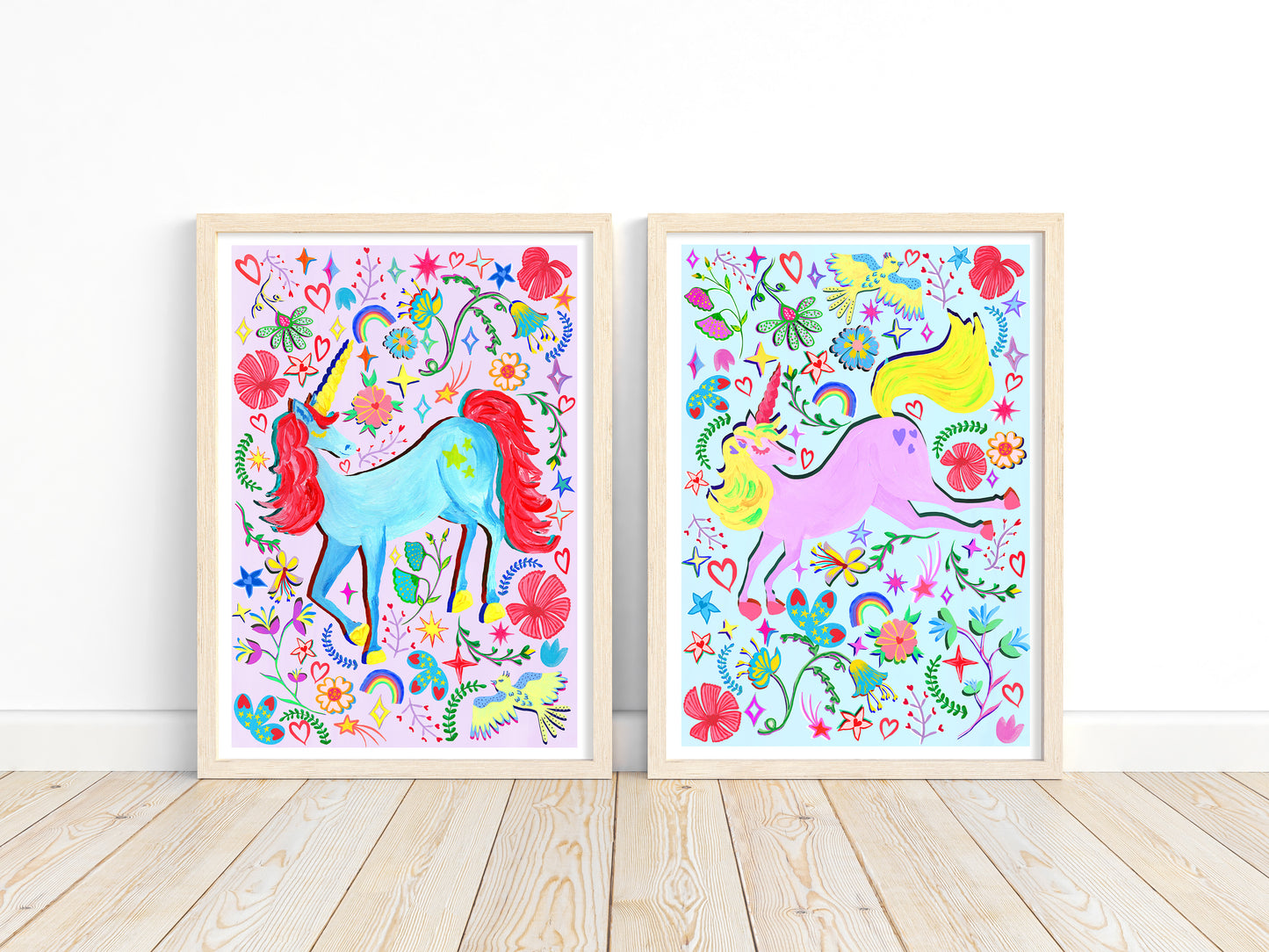 Two colorful unicorn prints with floral designs on a white wall.