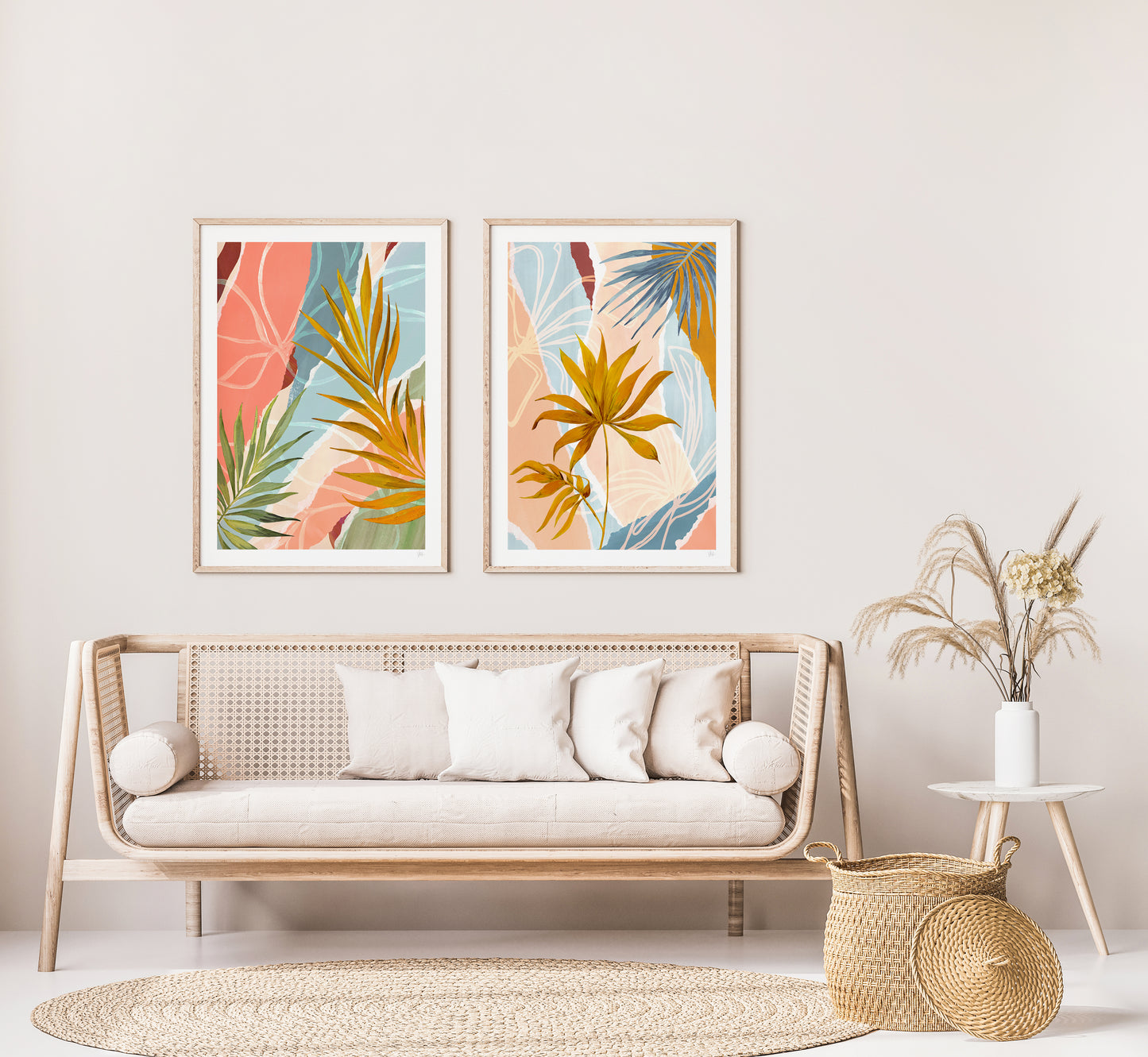 Living room with a wicker sofa, decorative pillows, and two framed tropical leaf prints on the wall.