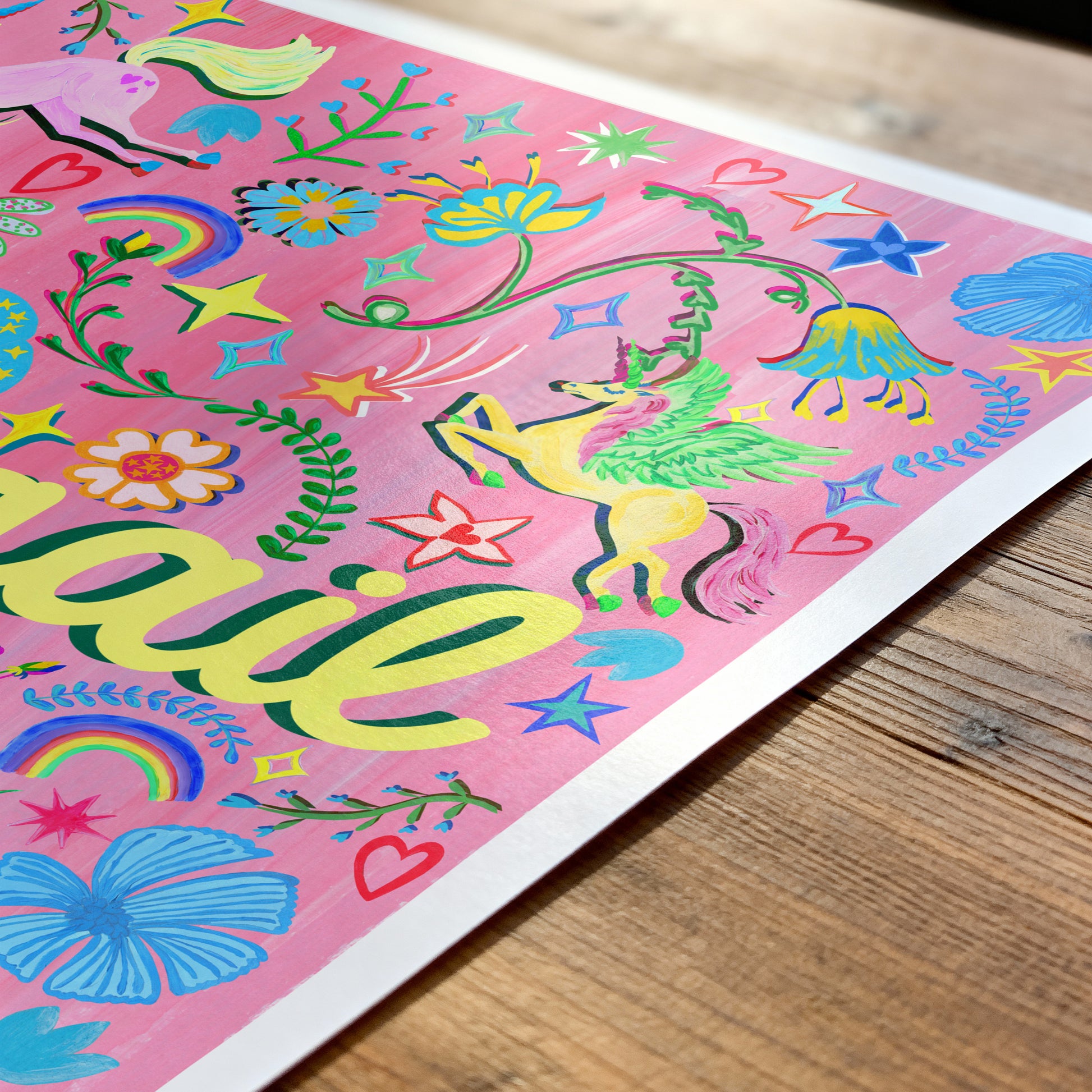 Colorful children's artwork with 'Natalie' on a pink background, displayed on a wooden surface.