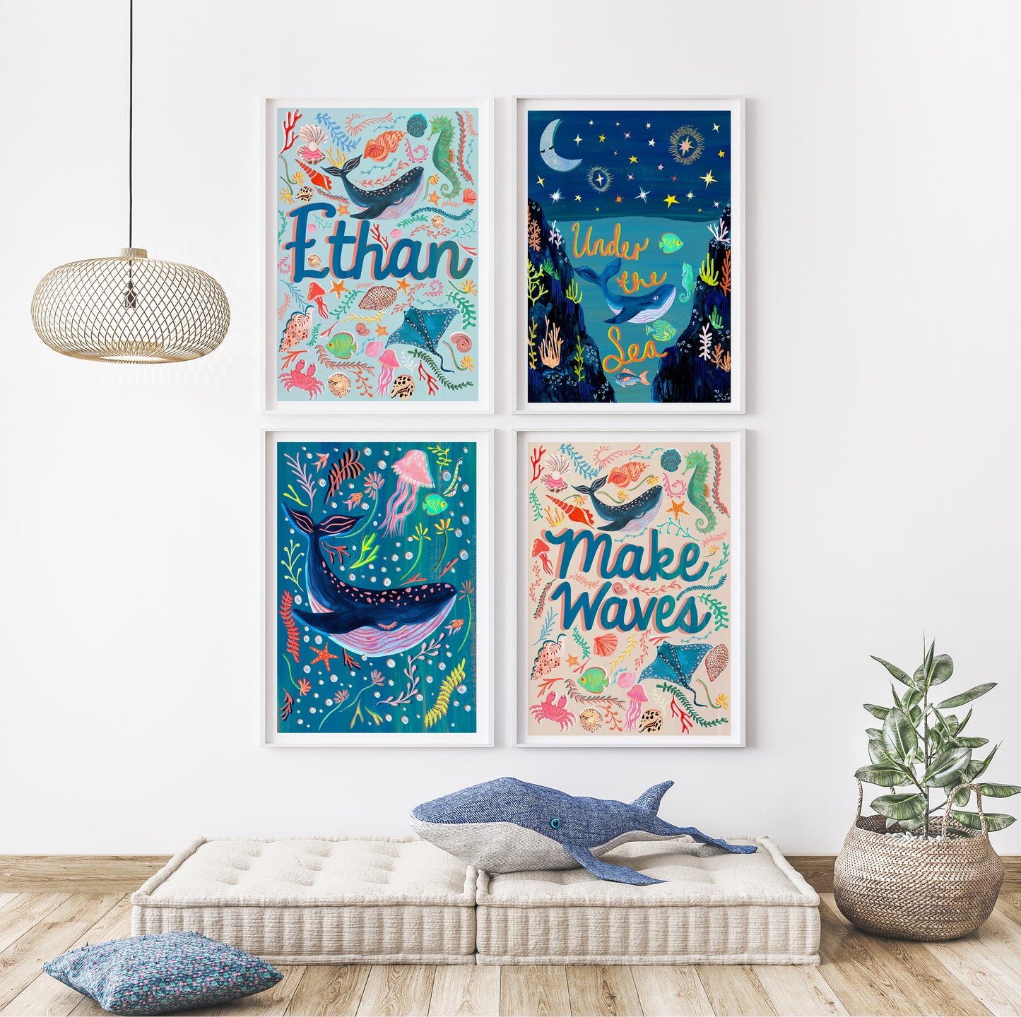 Four colorful framed artworks with whale-themed designs on a wall above a bench.