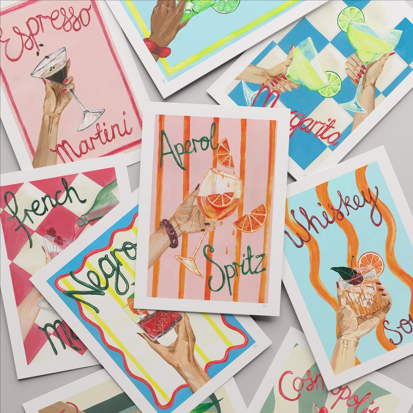 Collection of colorful cocktail-themed prints on a gray surface