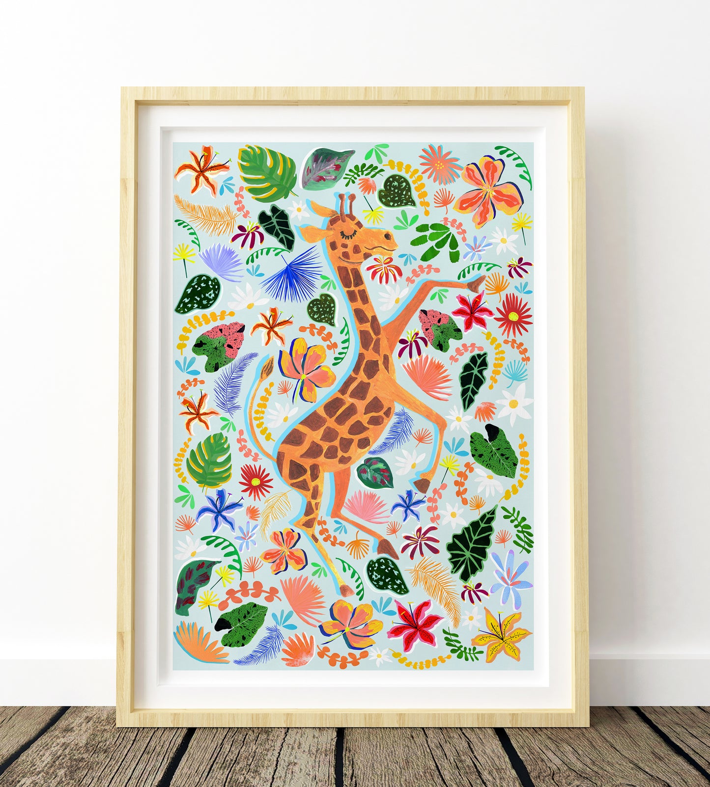 Framed artwork of a giraffe among colorful flowers and leaves on a white wall.
