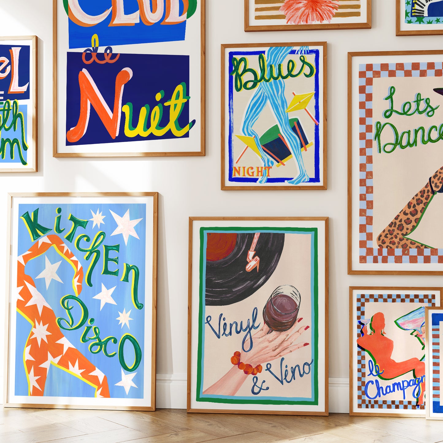 Wall with various colorful framed posters on a white wall.
