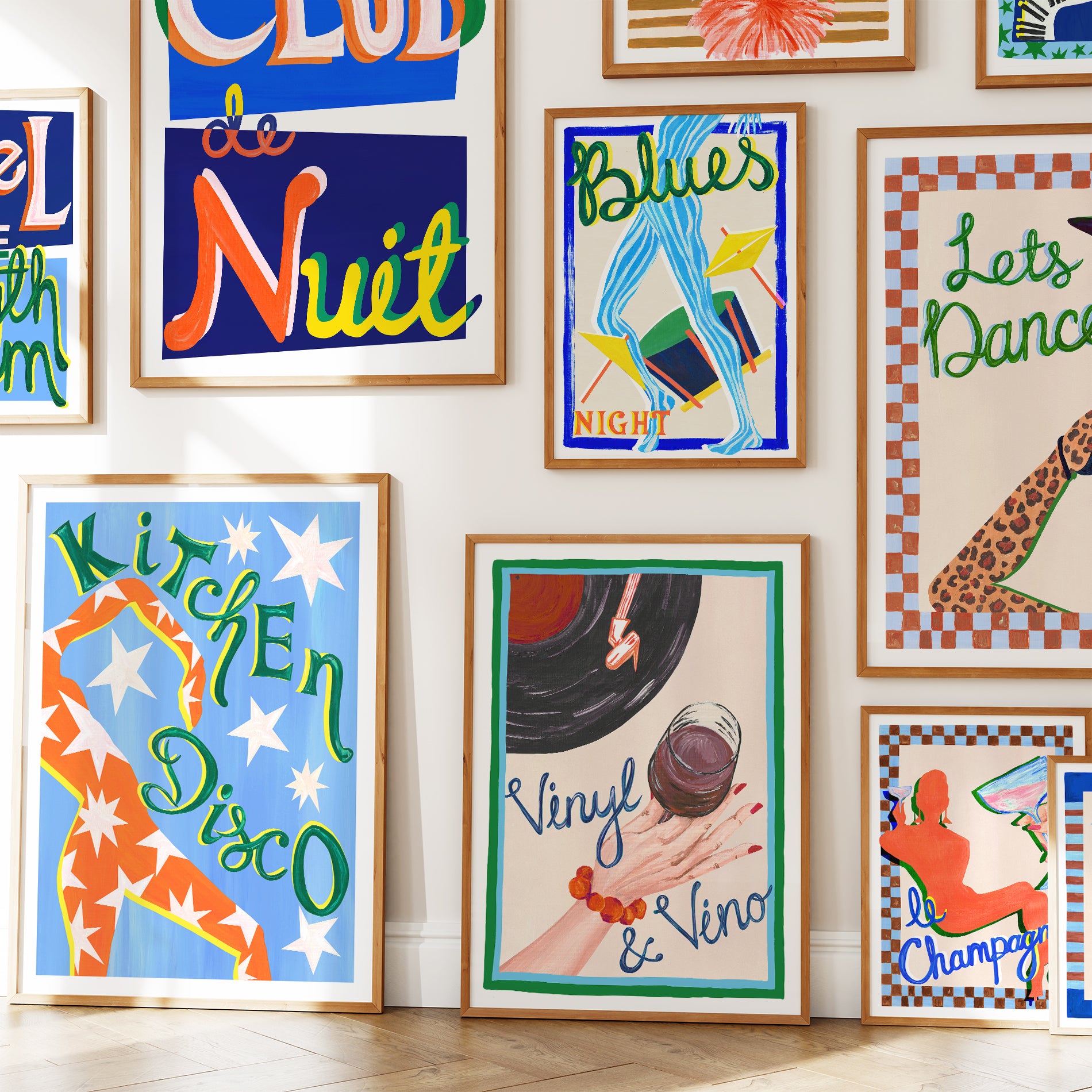 Wall with various colorful framed posters on a white wall.