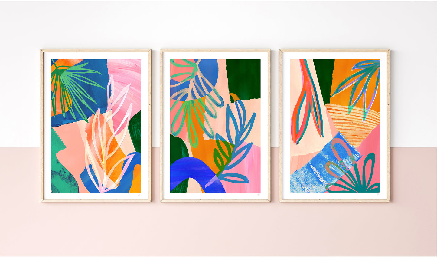 Three colorful abstract art prints on a light pink wall.