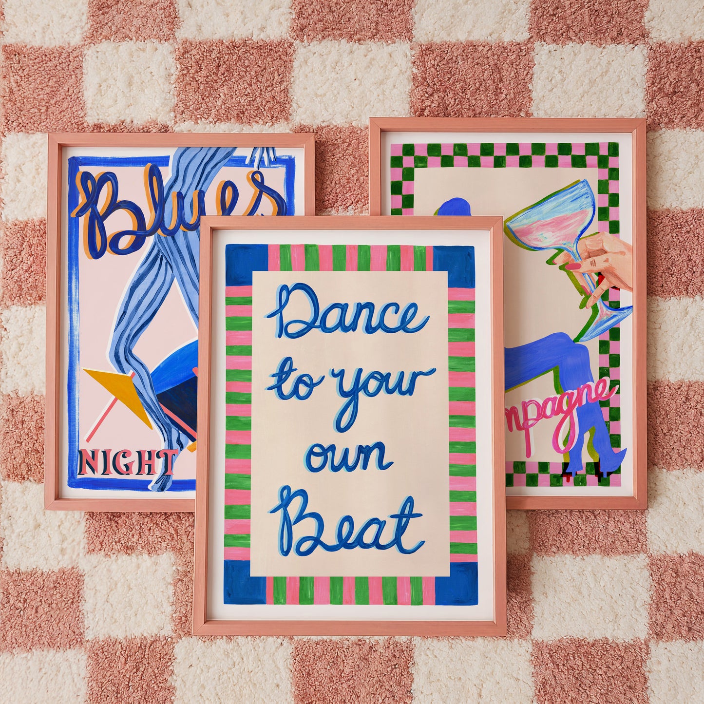 Three framed artworks on a textured wall with checkered pattern