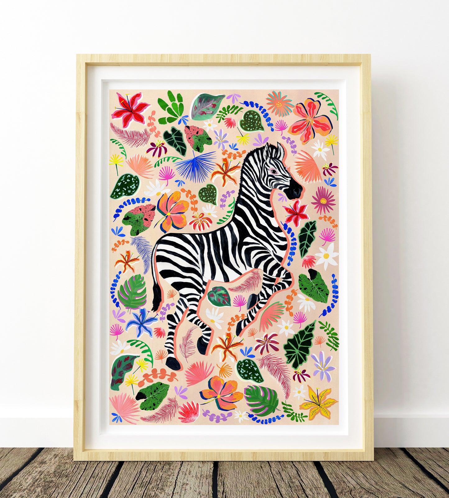 Framed artwork of a zebra surrounded by colorful flowers and leaves on a white wall.