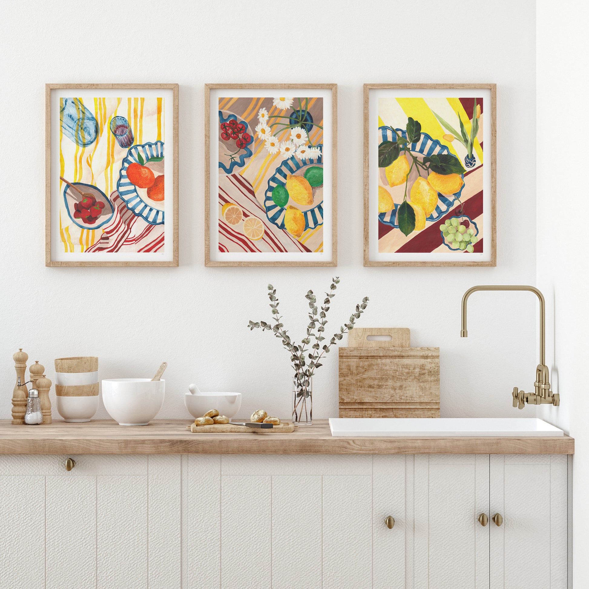 Kitchen with wooden countertop, sink, and three colorful framed artworks on the wall.