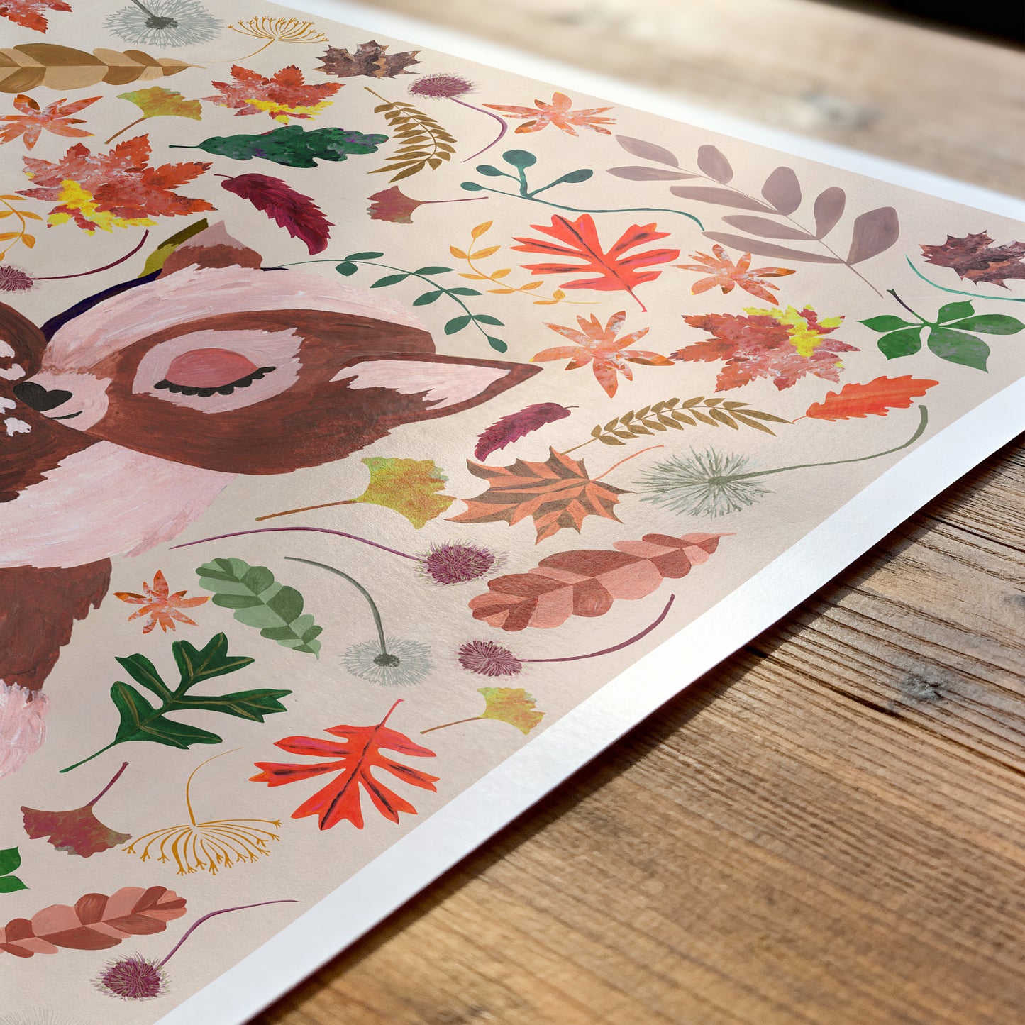 Colorful illustration of a deer and autumn leaves on a wooden surface