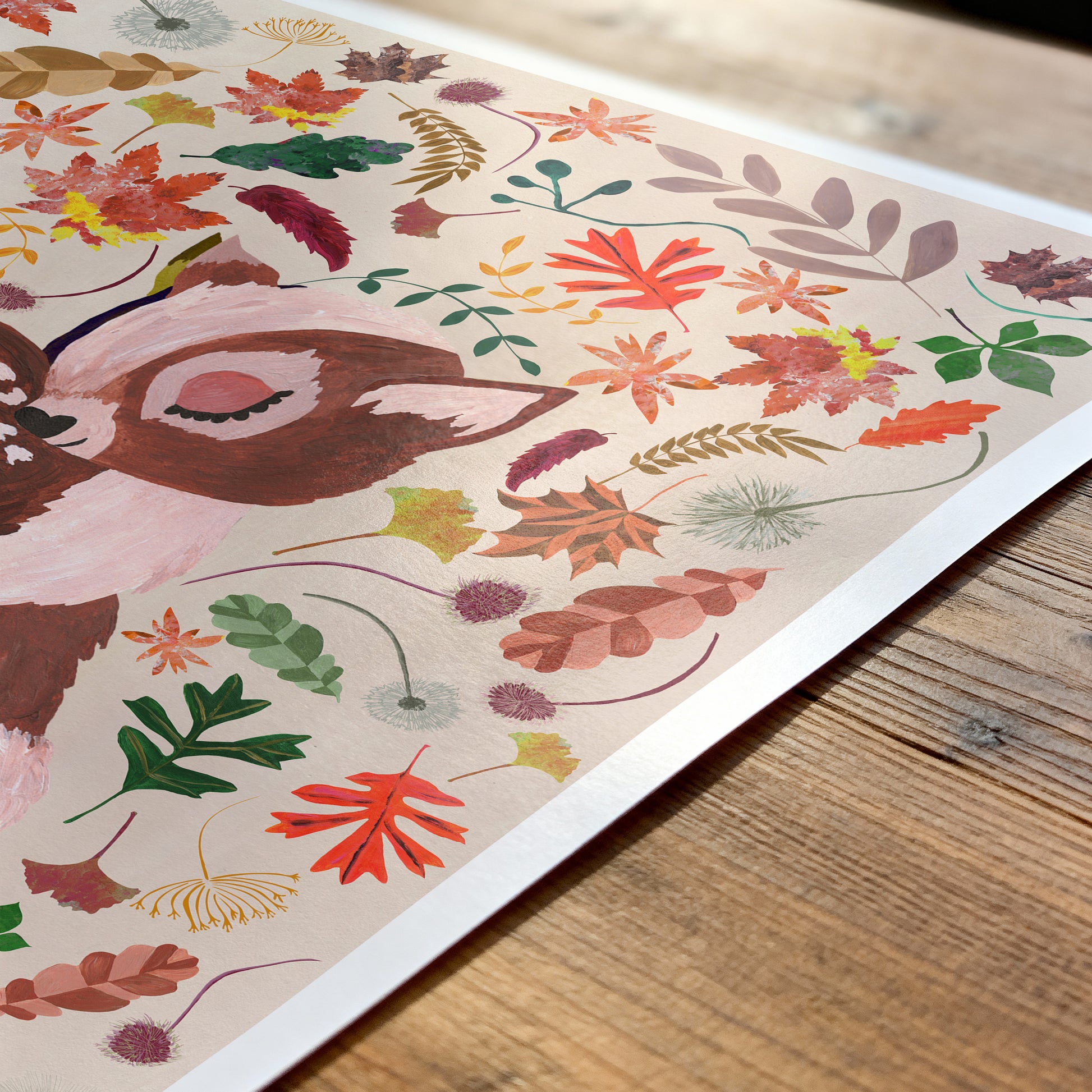 Colorful illustration of a deer and autumn leaves on a wooden surface
