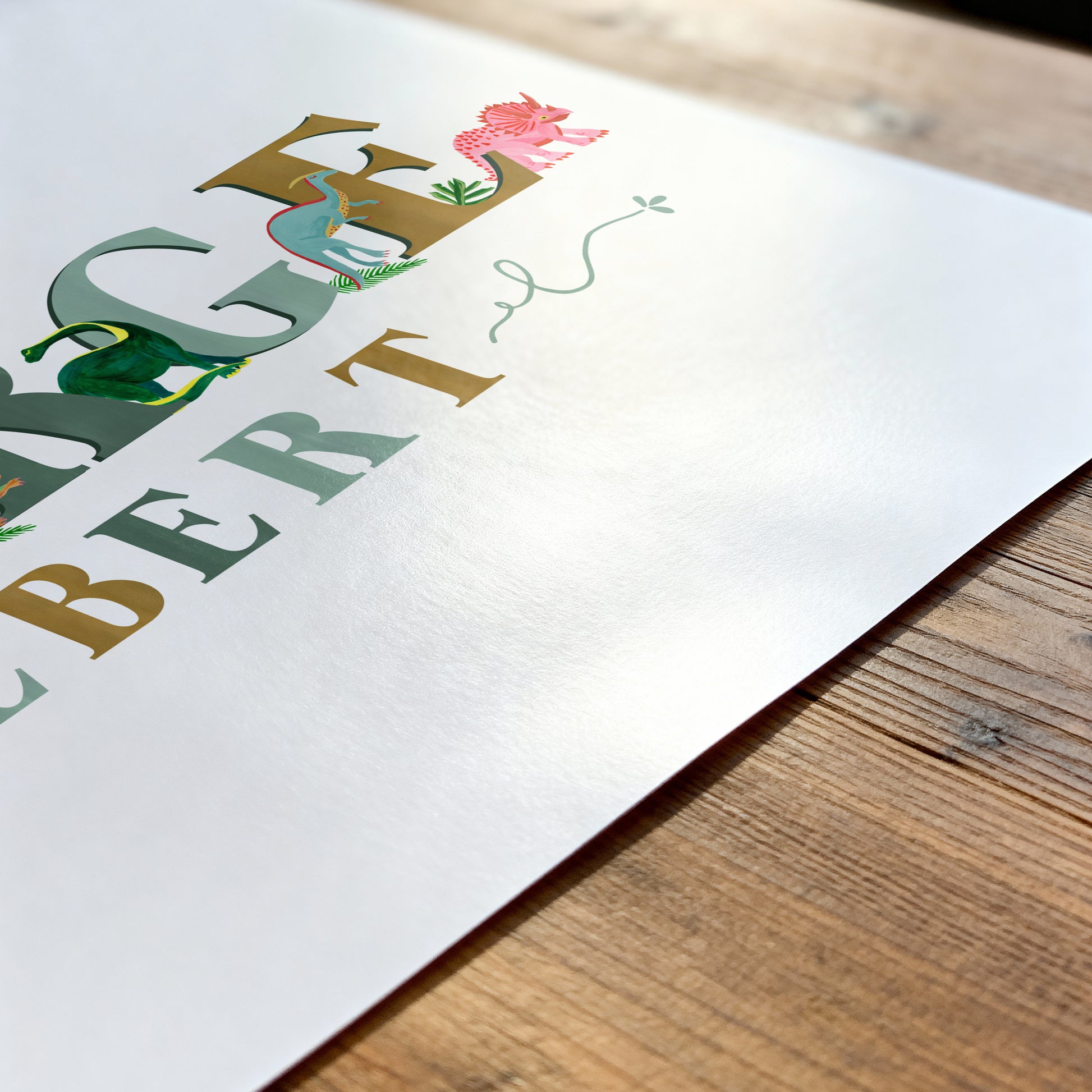 Colorful dinosaur name with dinosaur illustrations on a white paper with a wooden surface underneath