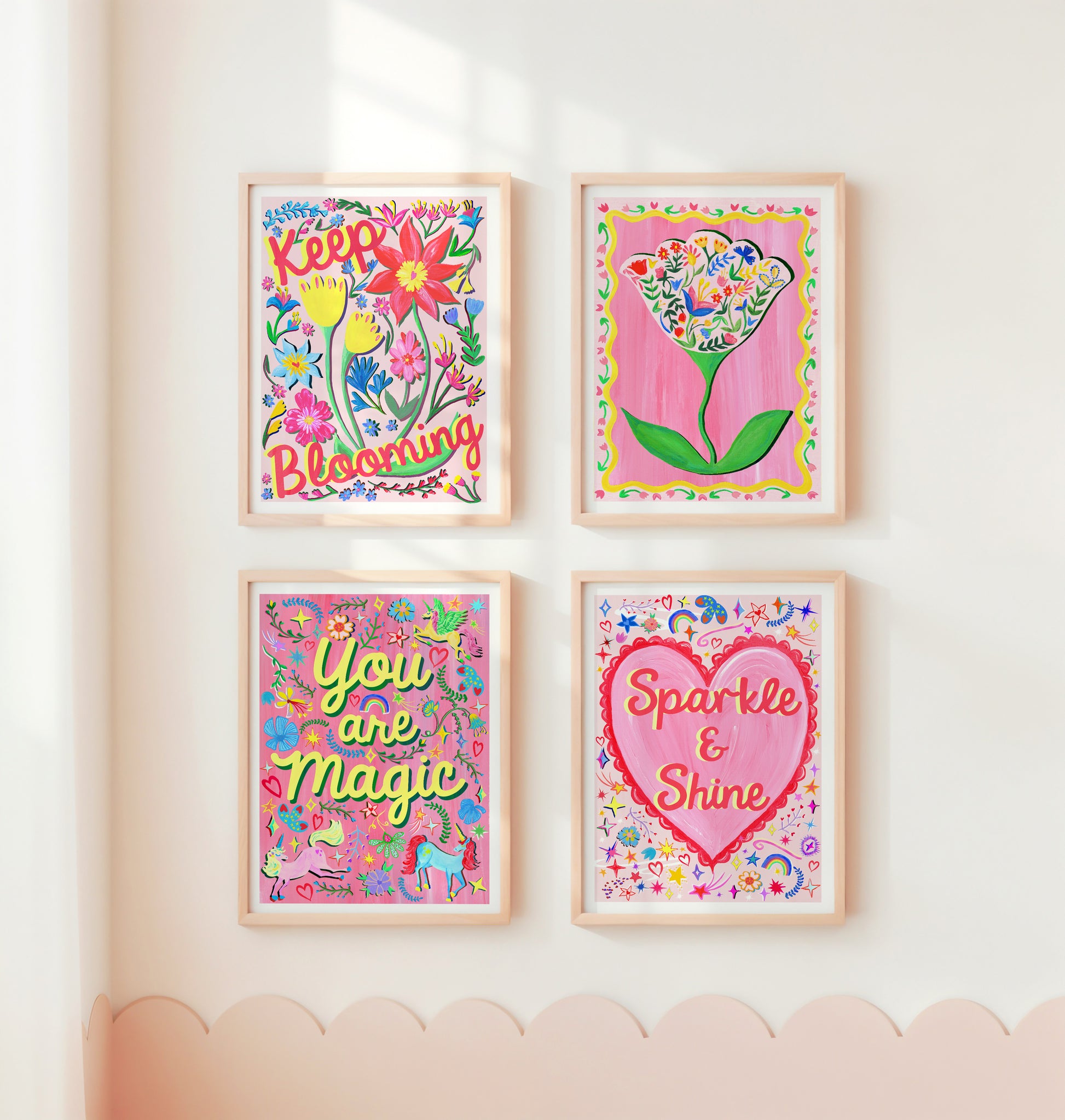 Four colorful framed prints with motivational phrases on a wall.