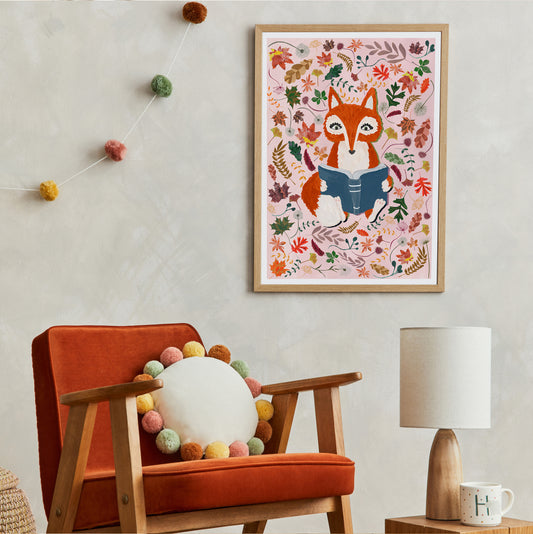 Framed artwork of a fox surrounded by autumn leave above an orange armchair with decorative elements.