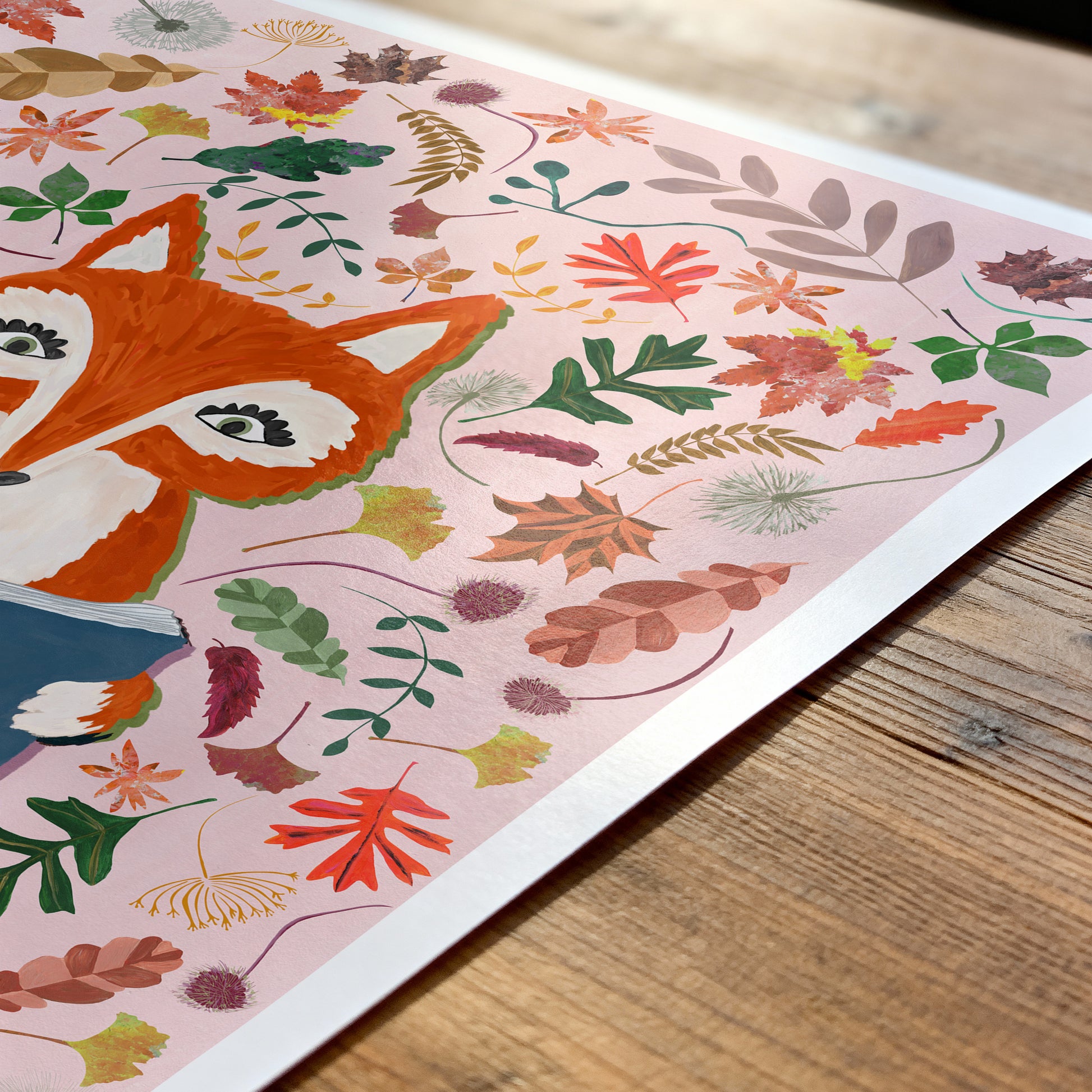 Illustration of a fox surrounded by autumn leaves on a wooden surface
