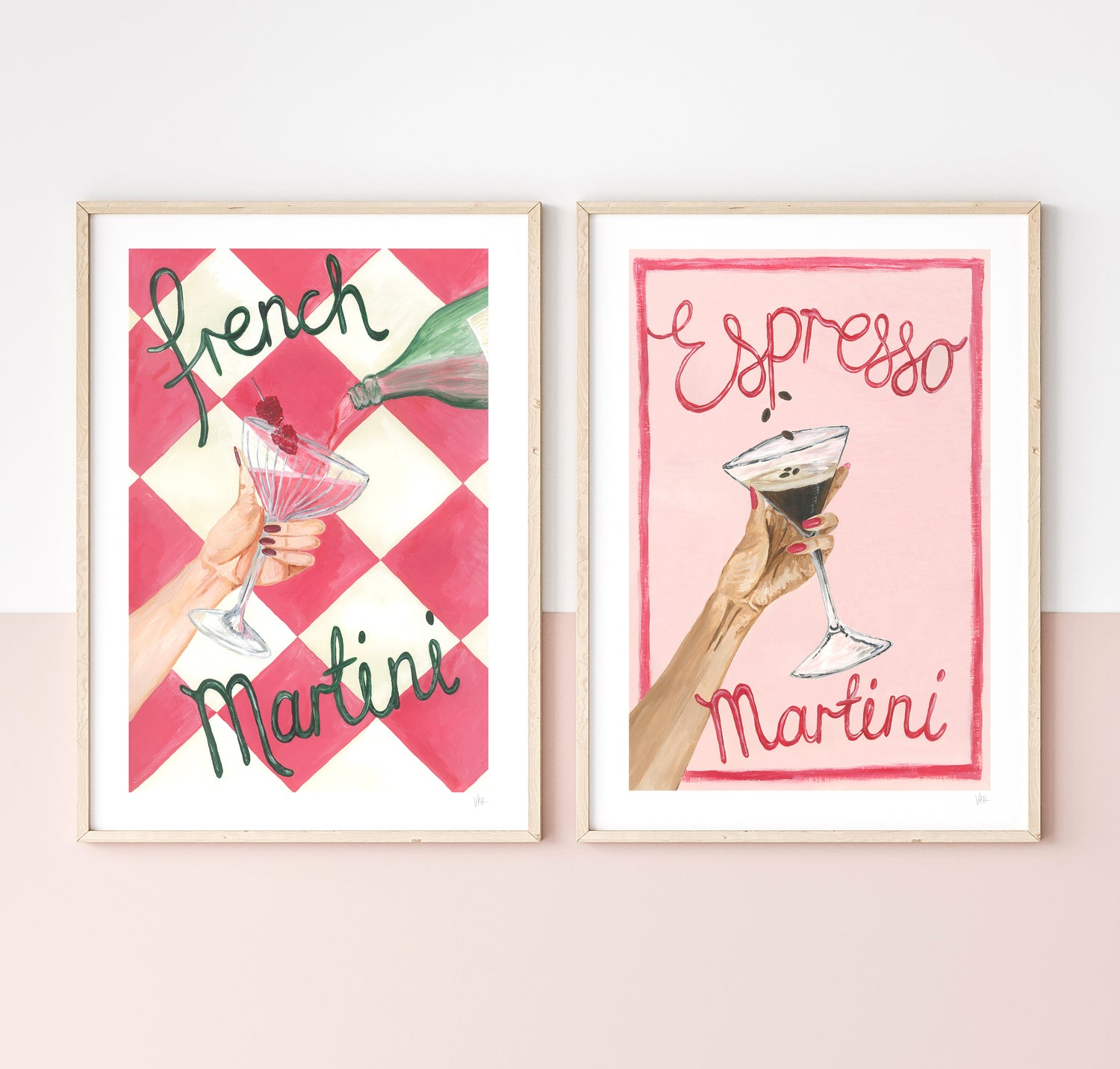 Two framed prints with illustrations of hands holding cocktails and text on a white wall.