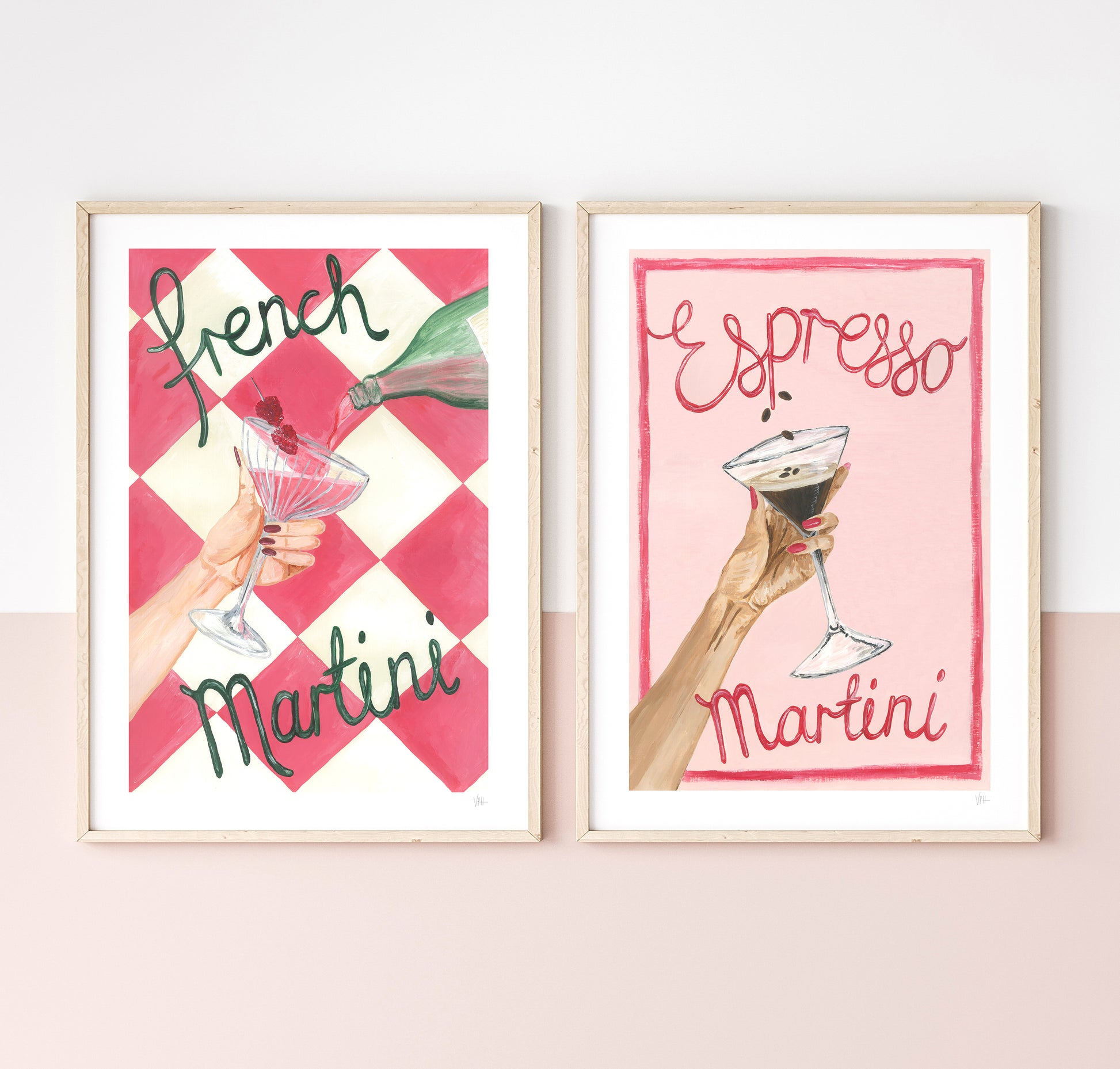 Two framed prints with illustrations of hands holding cocktails and text on a white wall.