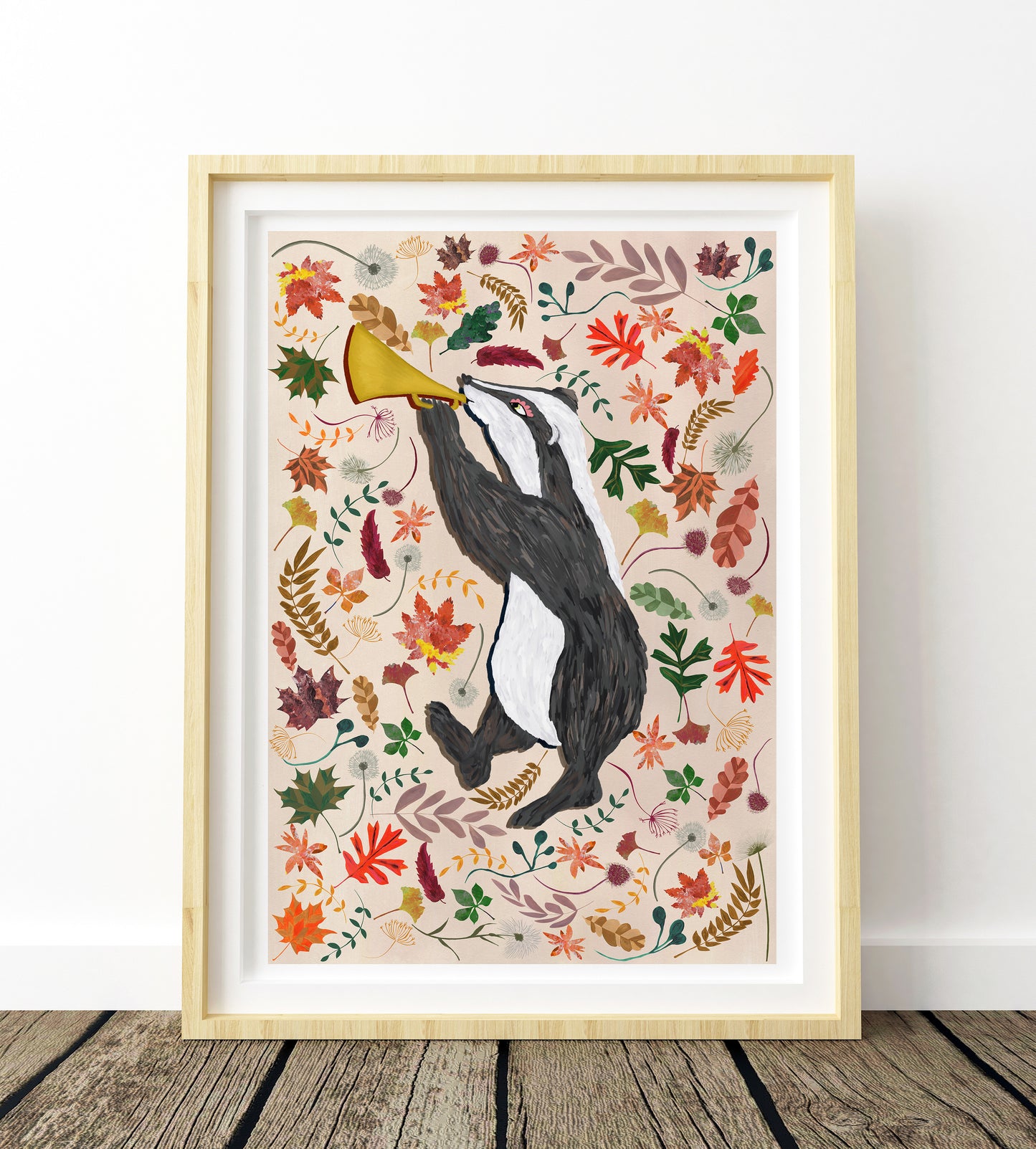 Framed artwork of a penguin with a megaphone surrounded by colorful leaves on a white background.