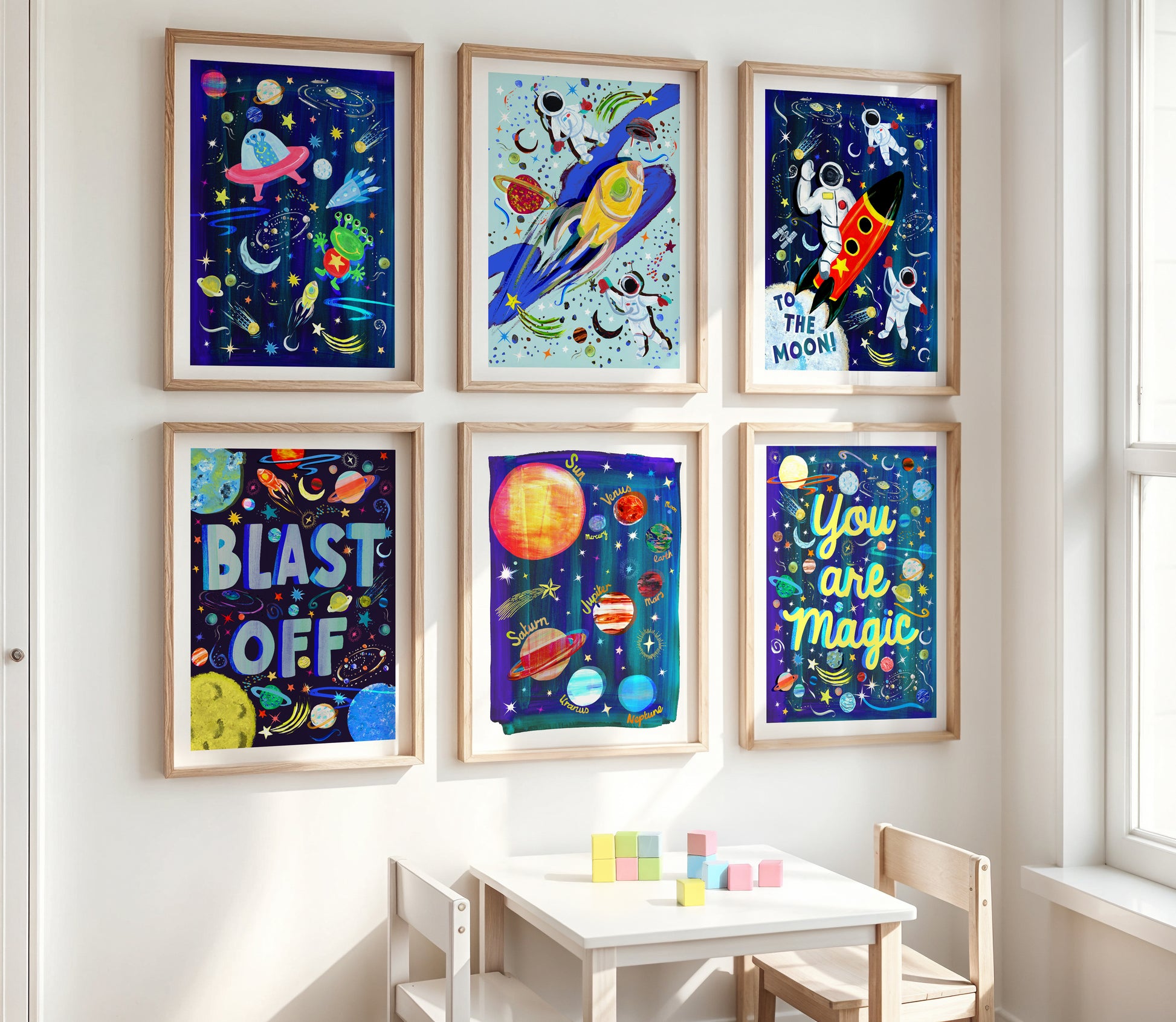 Colorful space-themed wall art prints on a white wall above a child's desk.