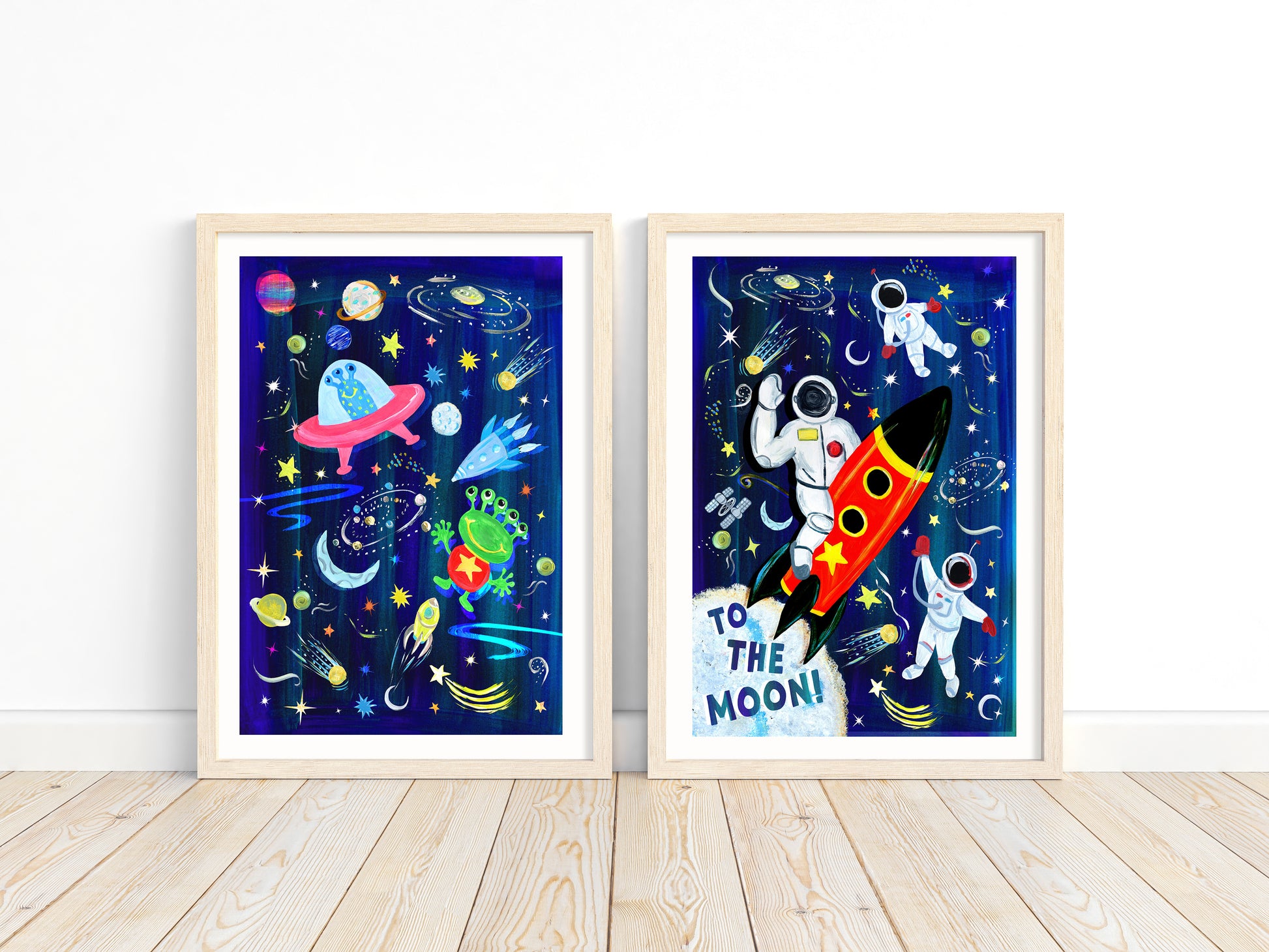 Two framed space-themed artworks on a white wall.