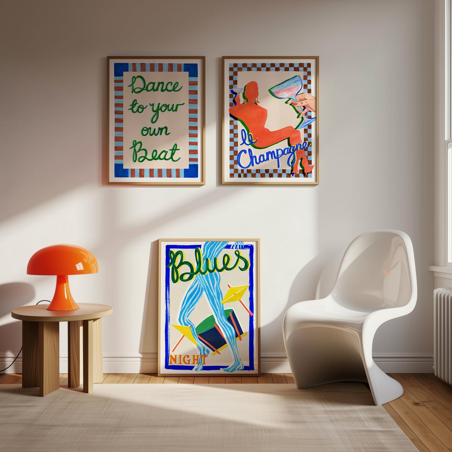Modern interior with colorful posters on the wall, a white chair, and a small table with an orange lamp.
