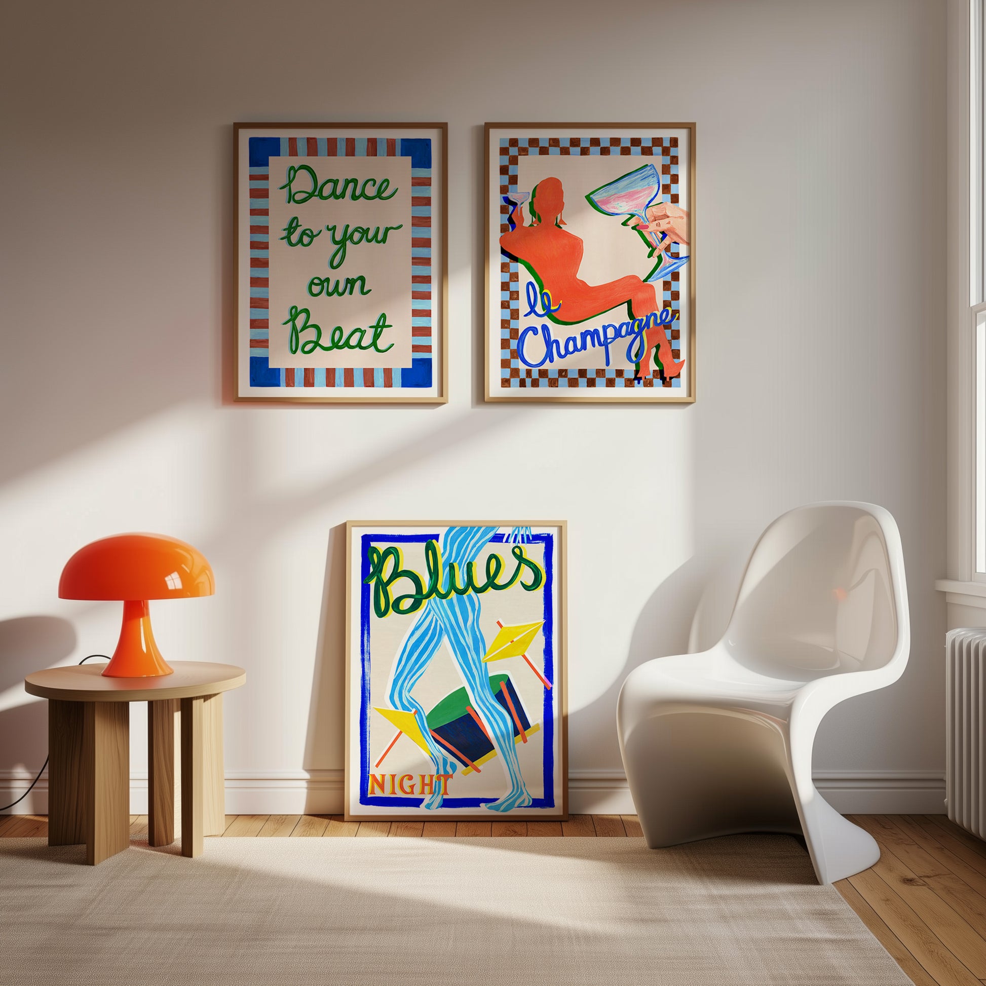 Modern interior with colorful posters on the wall, a white chair, and a small table with an orange lamp.
