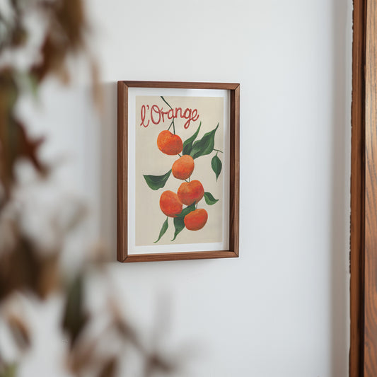 Framed artwork of oranges with 'L'Orange' text on a white wall.