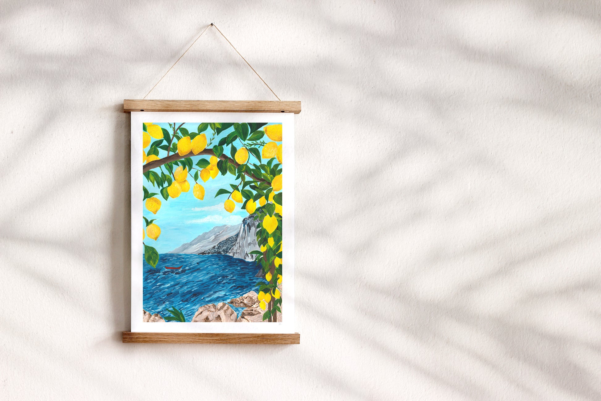 Framed artwork of a scenic view with lemons on a white wall