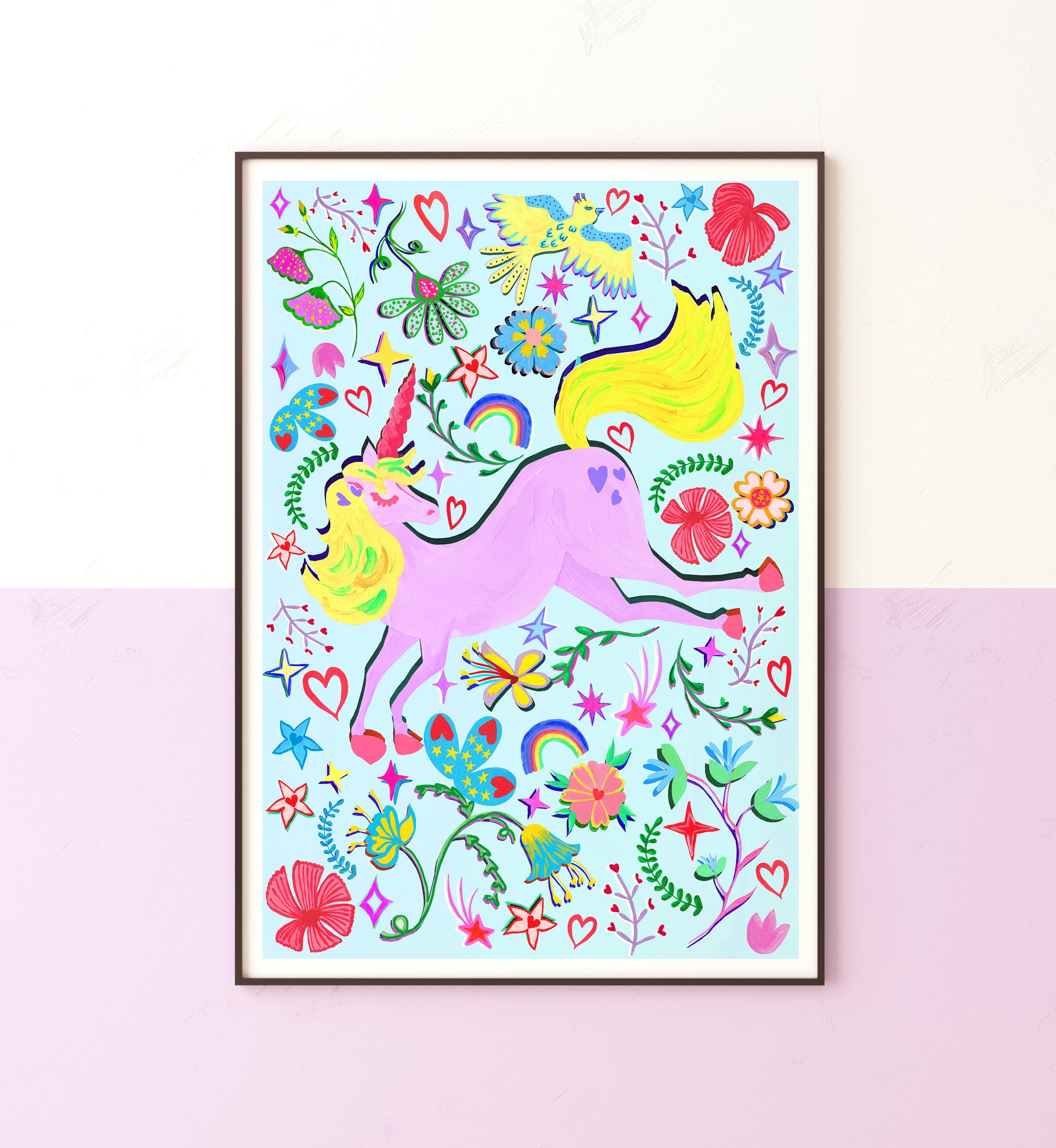 Colourful hand painted lilac unicorn print with rainbow and flower illustrations on a pake blue background in a black frame on a lilac and white wall.