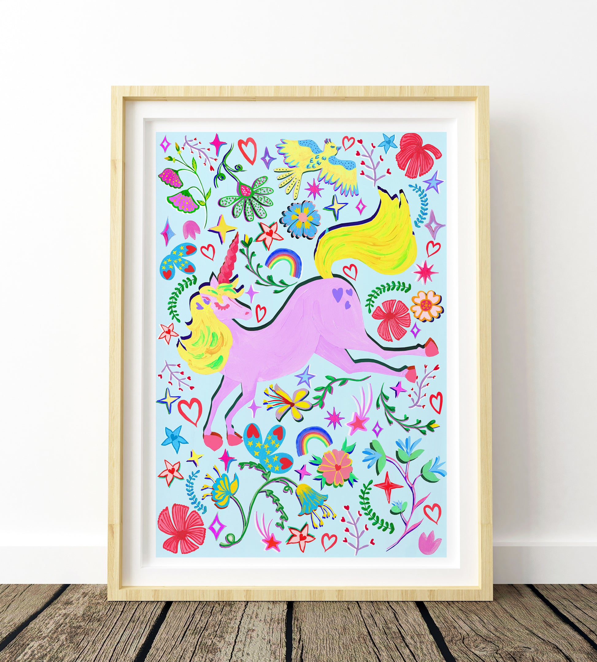 a colourful blue and liac unicorn painting in a light wood frame