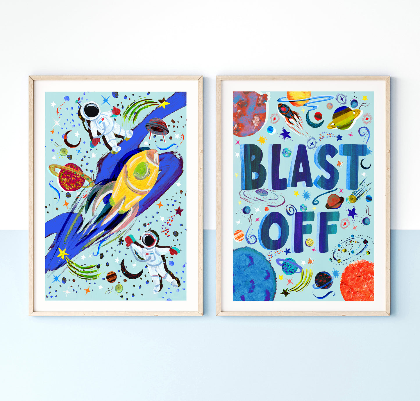Two colorful space-themed wall art prints with a rocket and 'Blast Off' text on a white background.