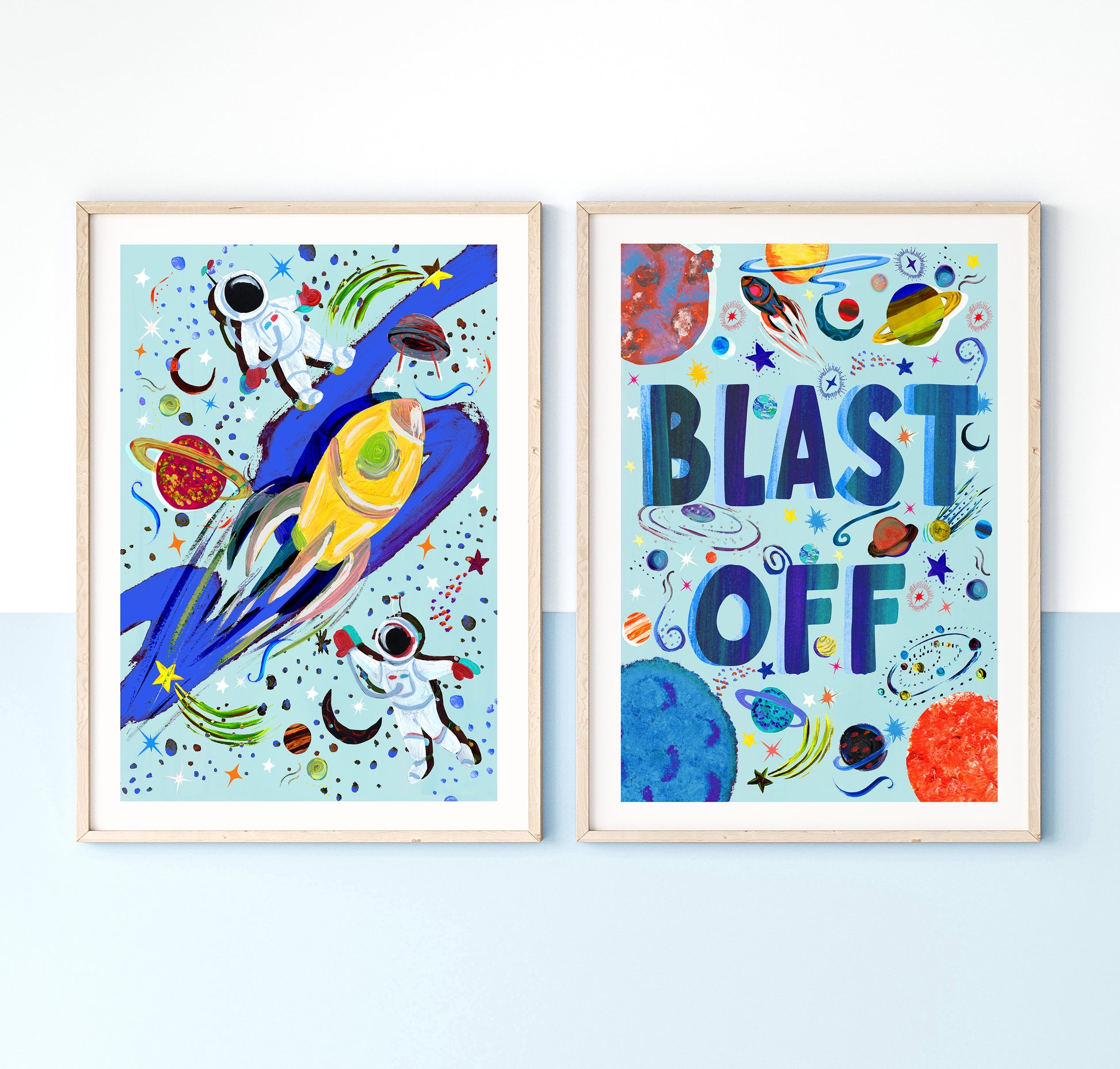 Two colorful space-themed wall art prints with a rocket and 'Blast Off' text on a white background.