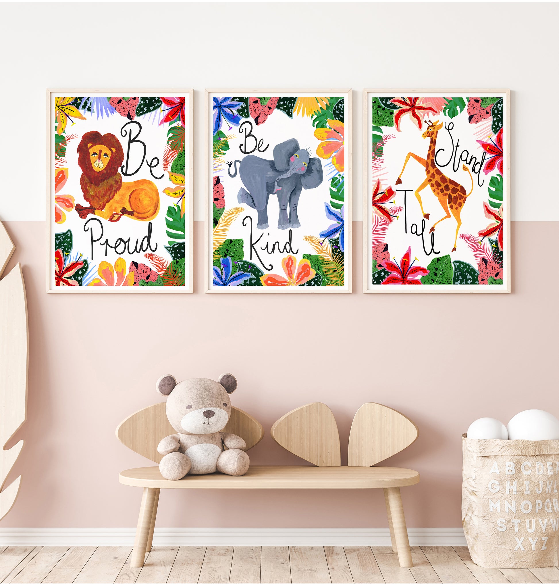 Three framed animal prints on a wall with a bench and toys below.