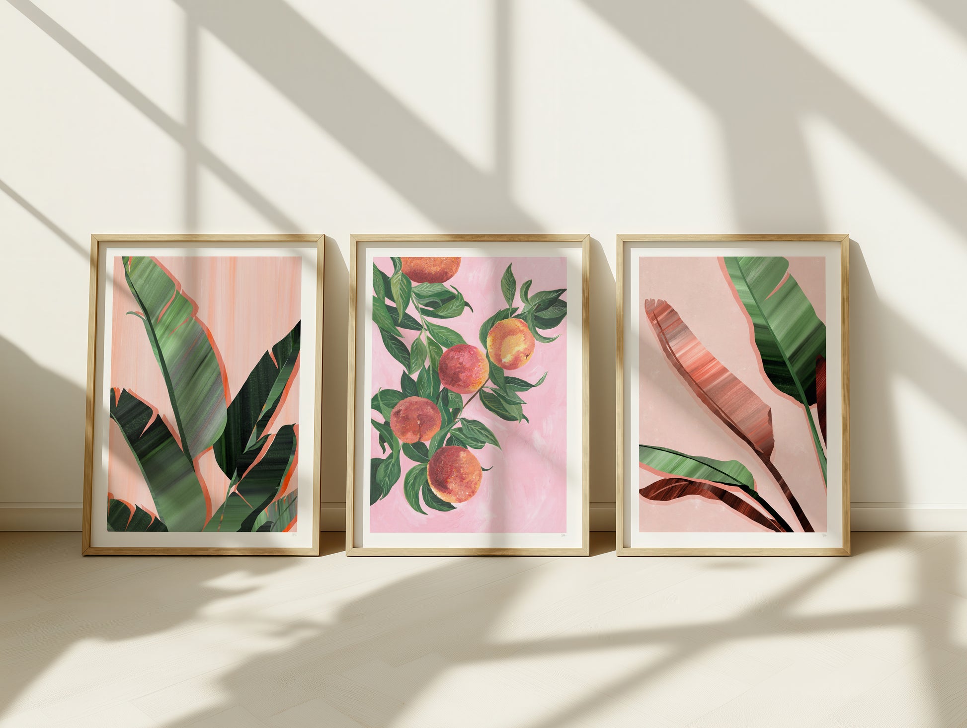 a set of 3 prints of tropical leaves and fruit painted in pink and green colours