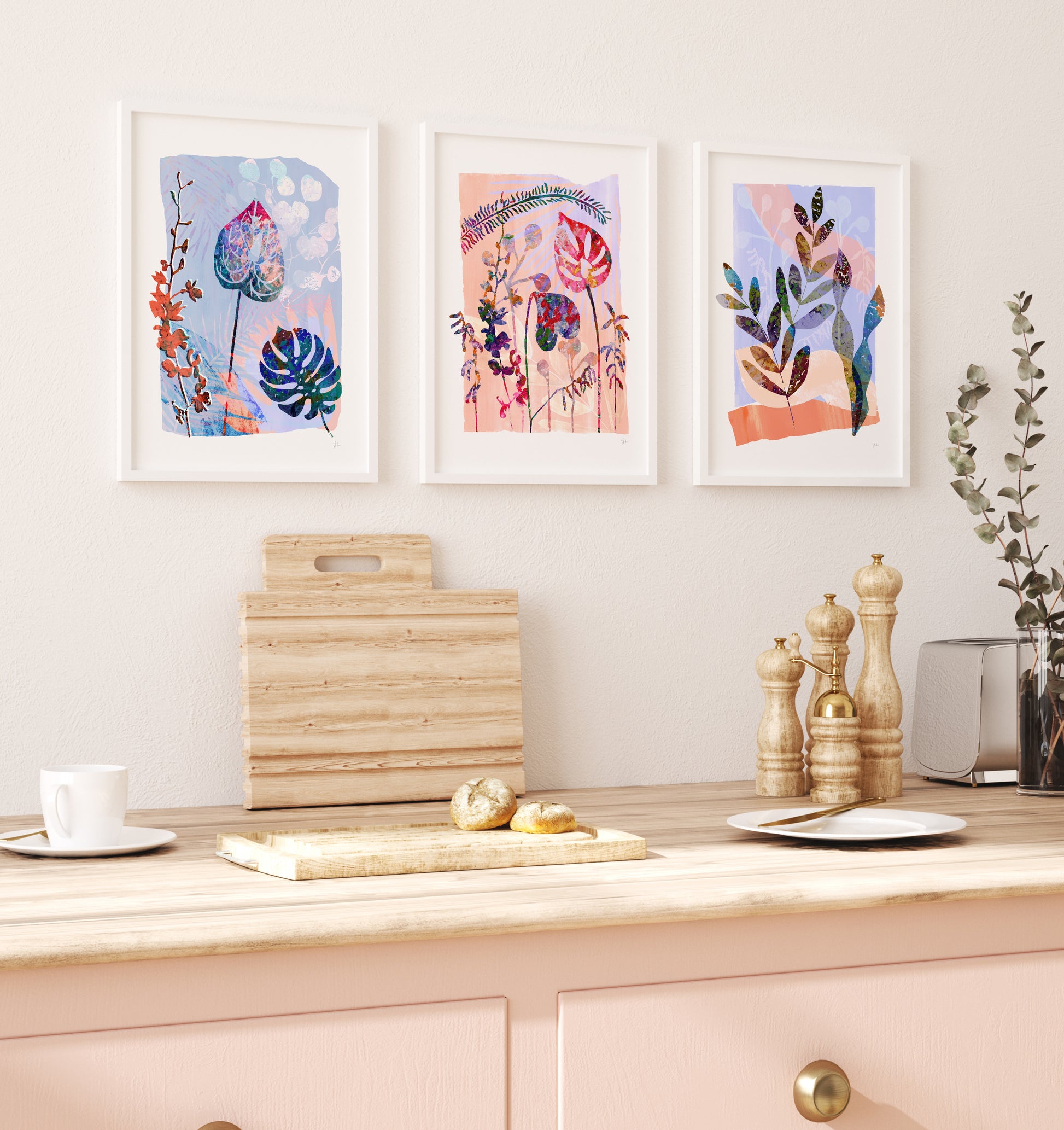 Kitchen counter with cutting board, plates, and decorative items against a wall with framed artwork.