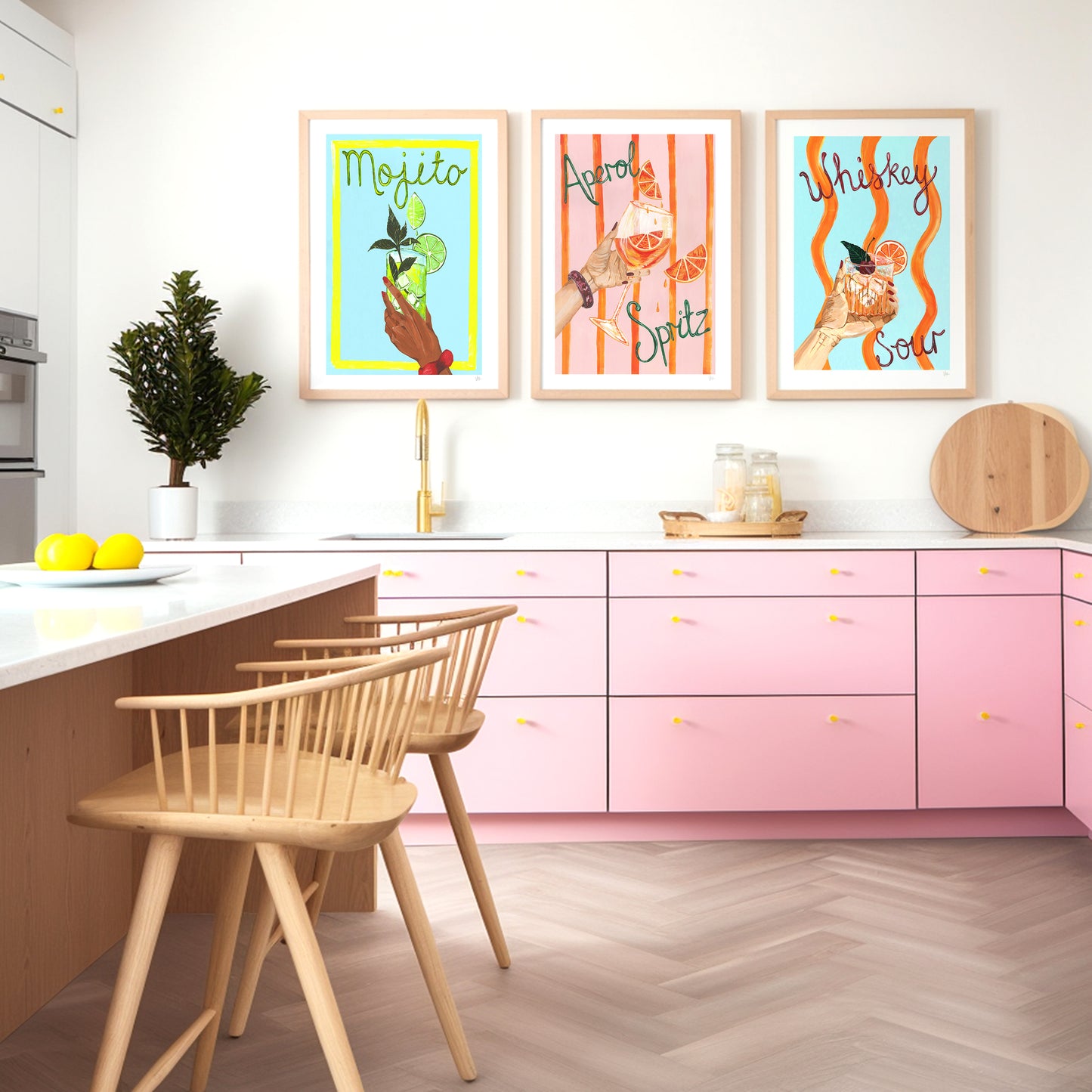 Modern kitchen with pink cabinets, wooden chairs, and colorful wall art.