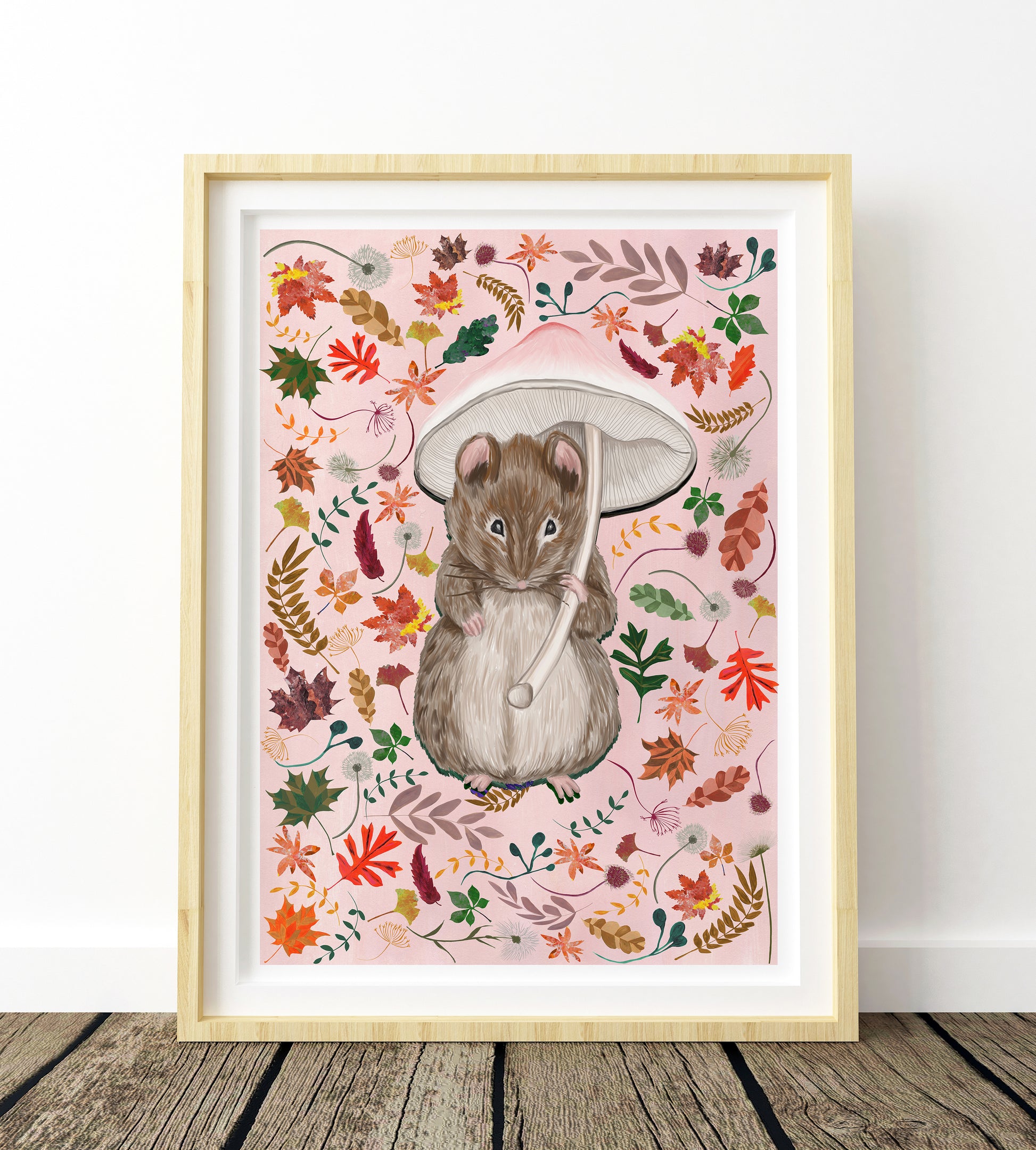Framed artwork of a mouse holding a mushroom with autumn leaves on a pink background
