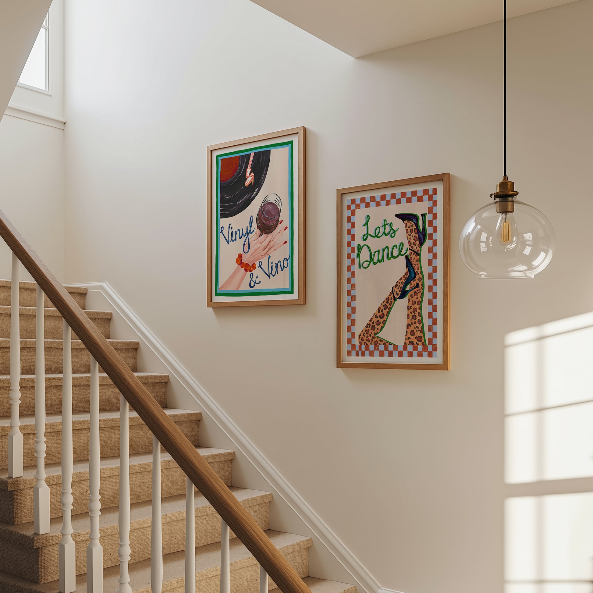 Staircase with framed artwork on the wall and a hanging light bulb.