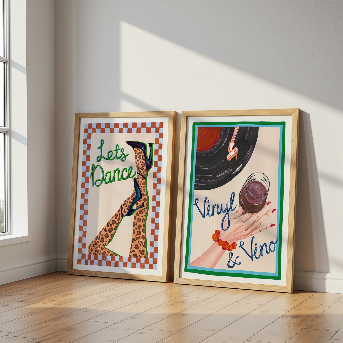 Two framed posters on a wall with 'Let's Dance' and 'Vinyl & Vino' text.
