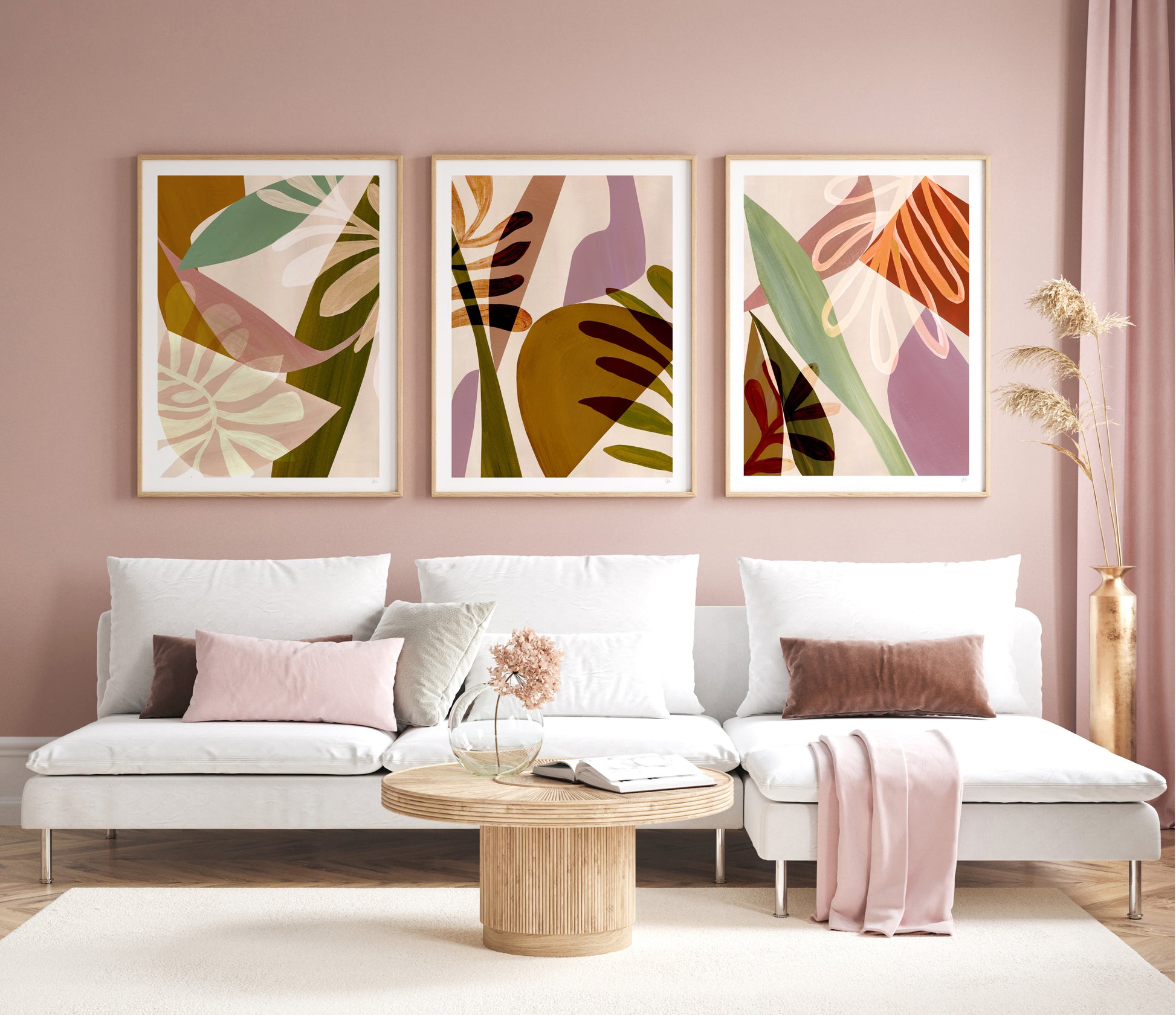 Living room with a white sofa, abstract leaf prints on the wall, and a wooden coffee table.