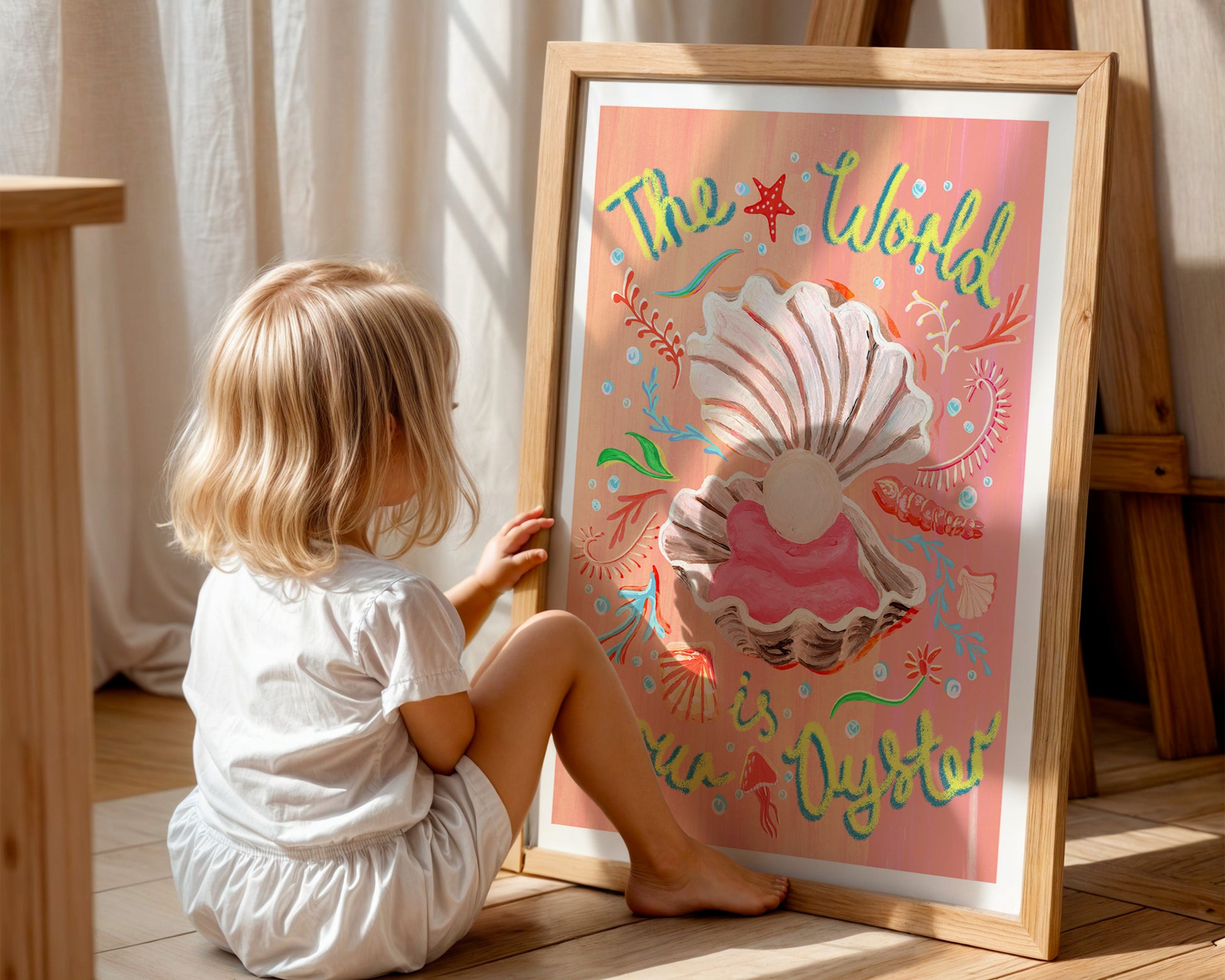 Child sitting on the floor next to a framed illustration with a shell and text.