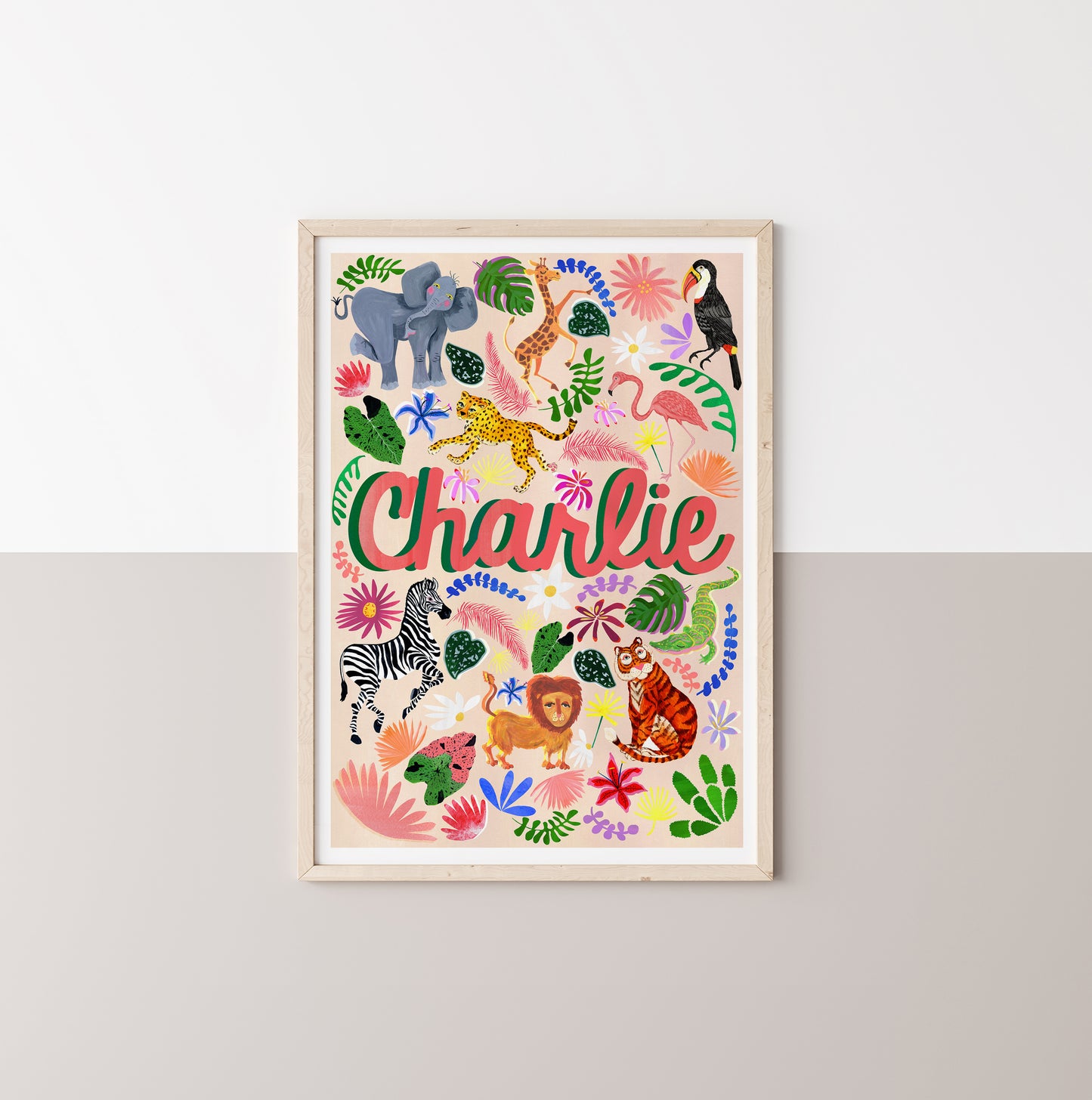 Framed children's poster with colorful animals and the name 'Charlie' on a white wall.