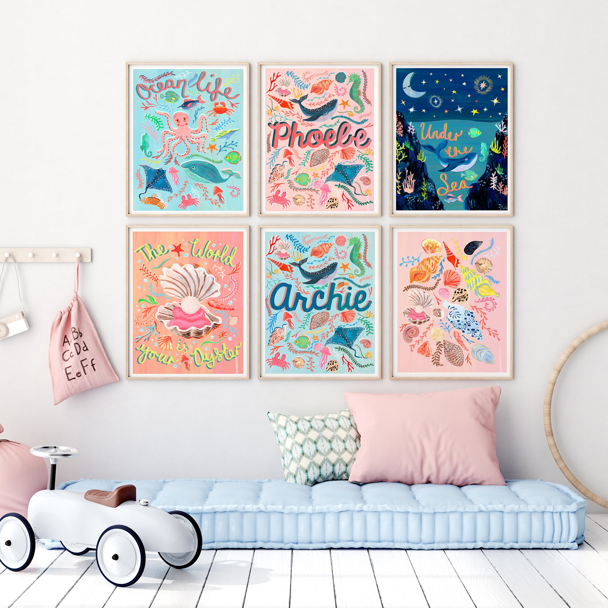 Colorful children's wall art prints on a wall above a bench with pillows.