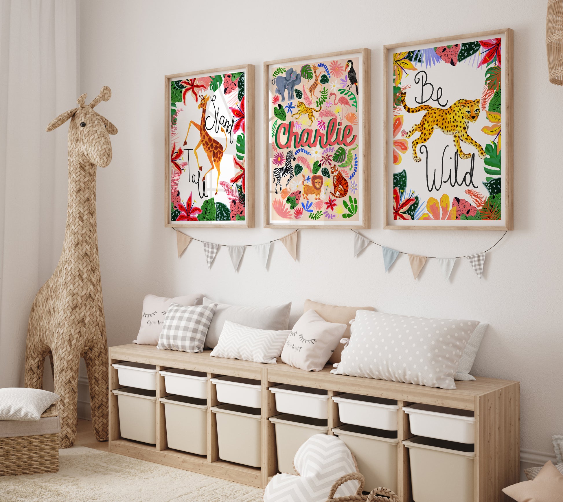 Children's room with framed artwork, storage unit, and stuffed giraffe.
