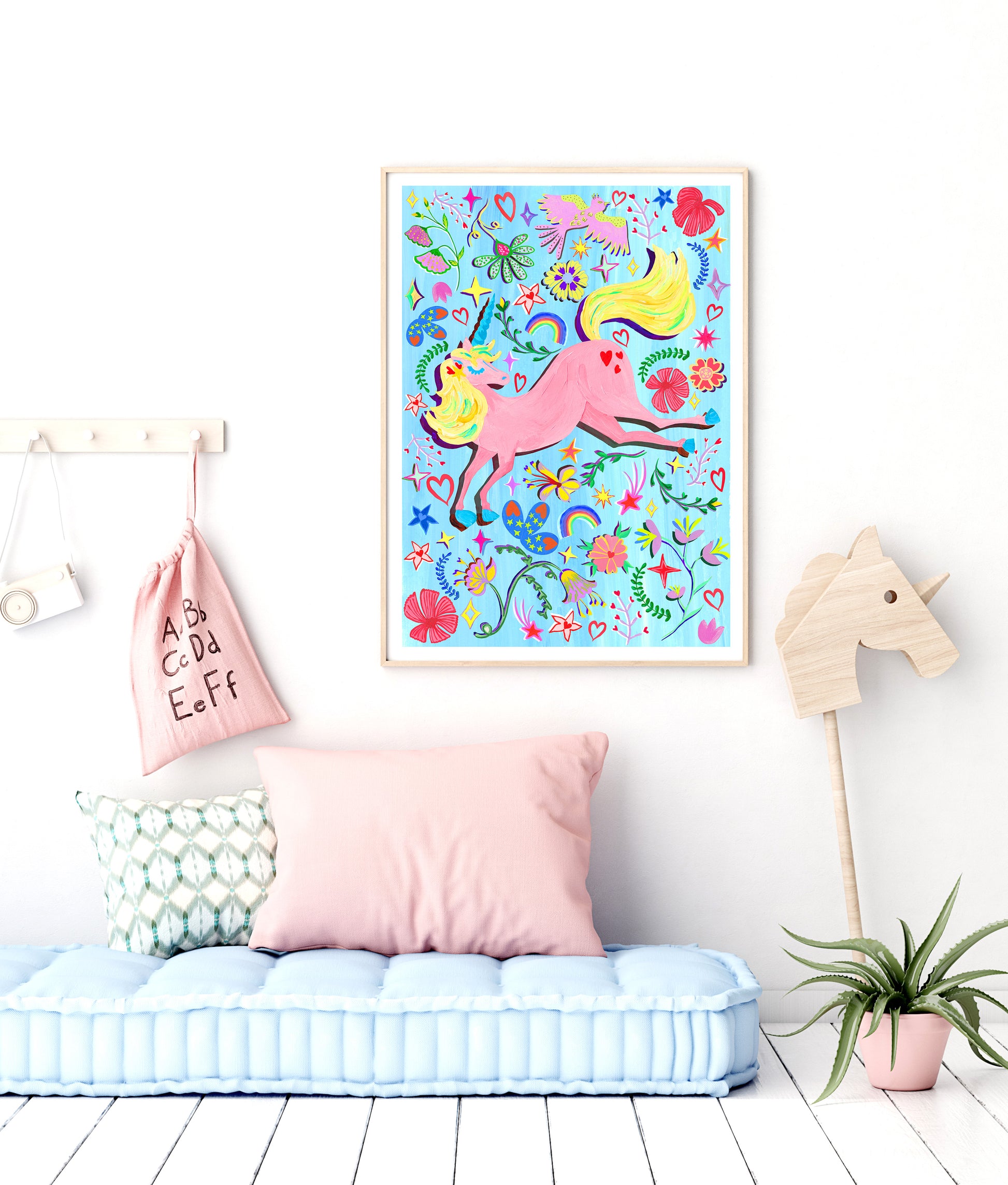 a kids room with a colourful illustrated uncorn print against a white wall