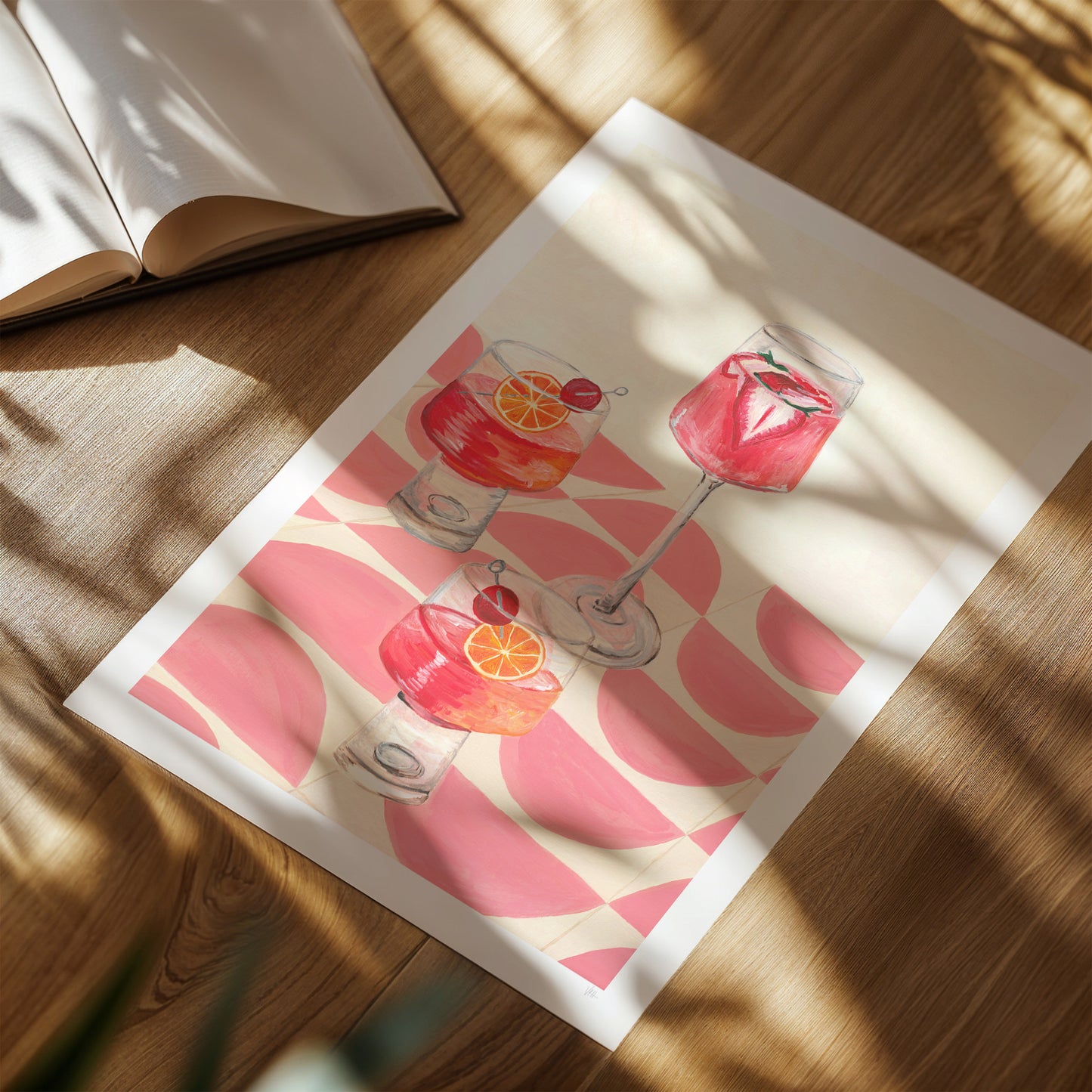 Print of drinks on a wooden surface with an open book