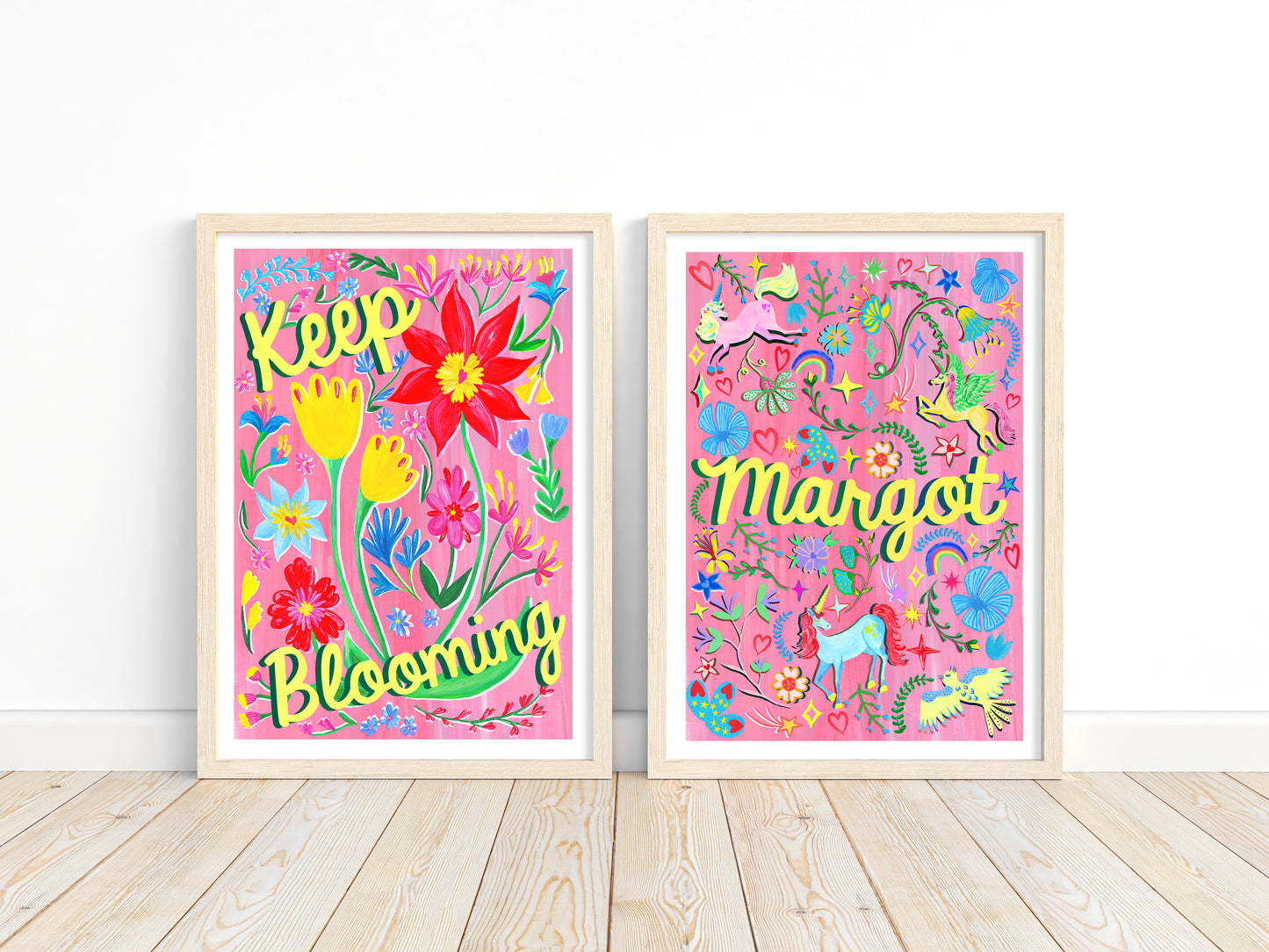 Two colorful framed artworks with floral designs and text on a white wall.