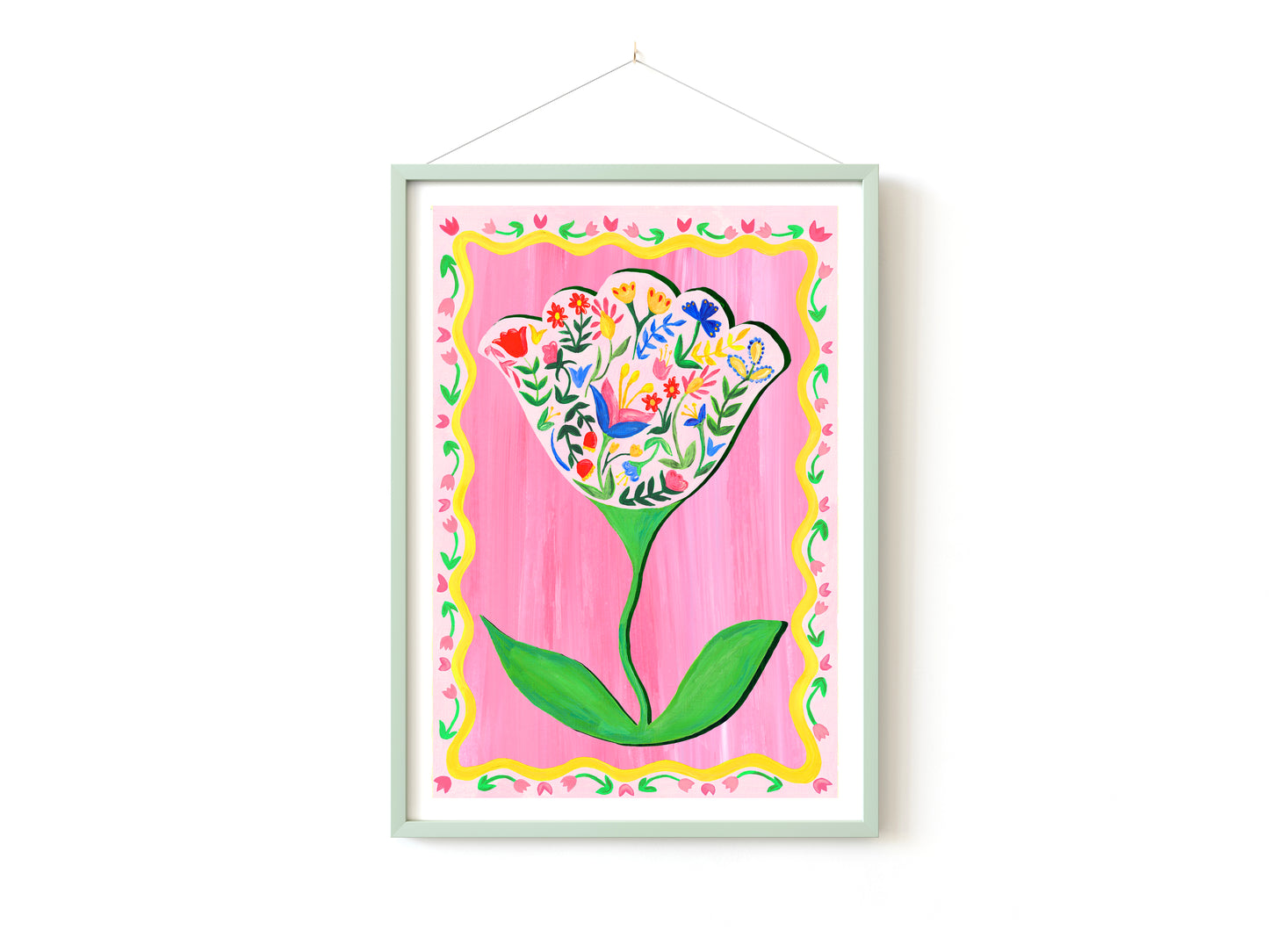 Framed artwork of a colorful flower design on a pink background