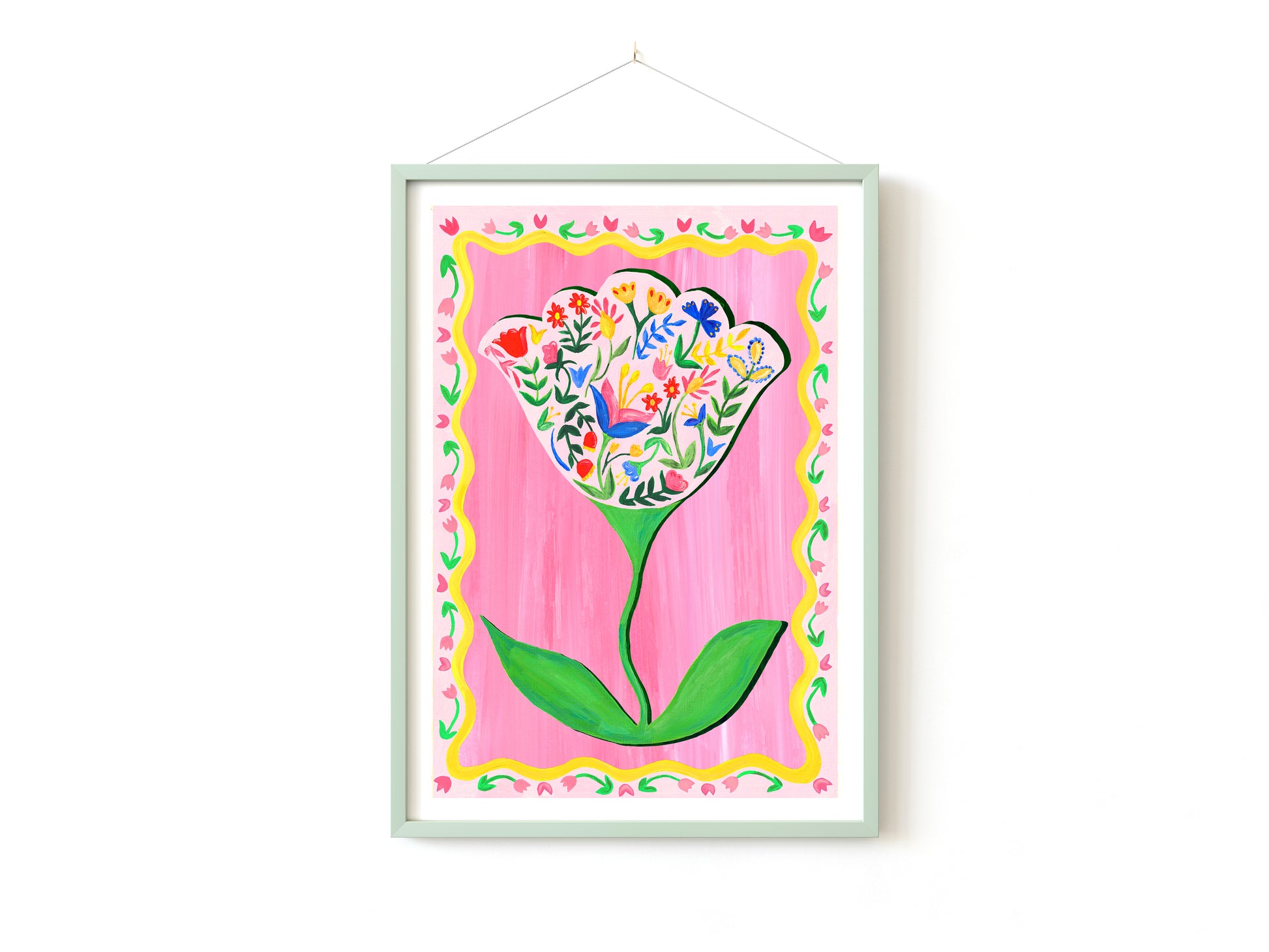 Framed artwork of a colorful flower design on a pink background